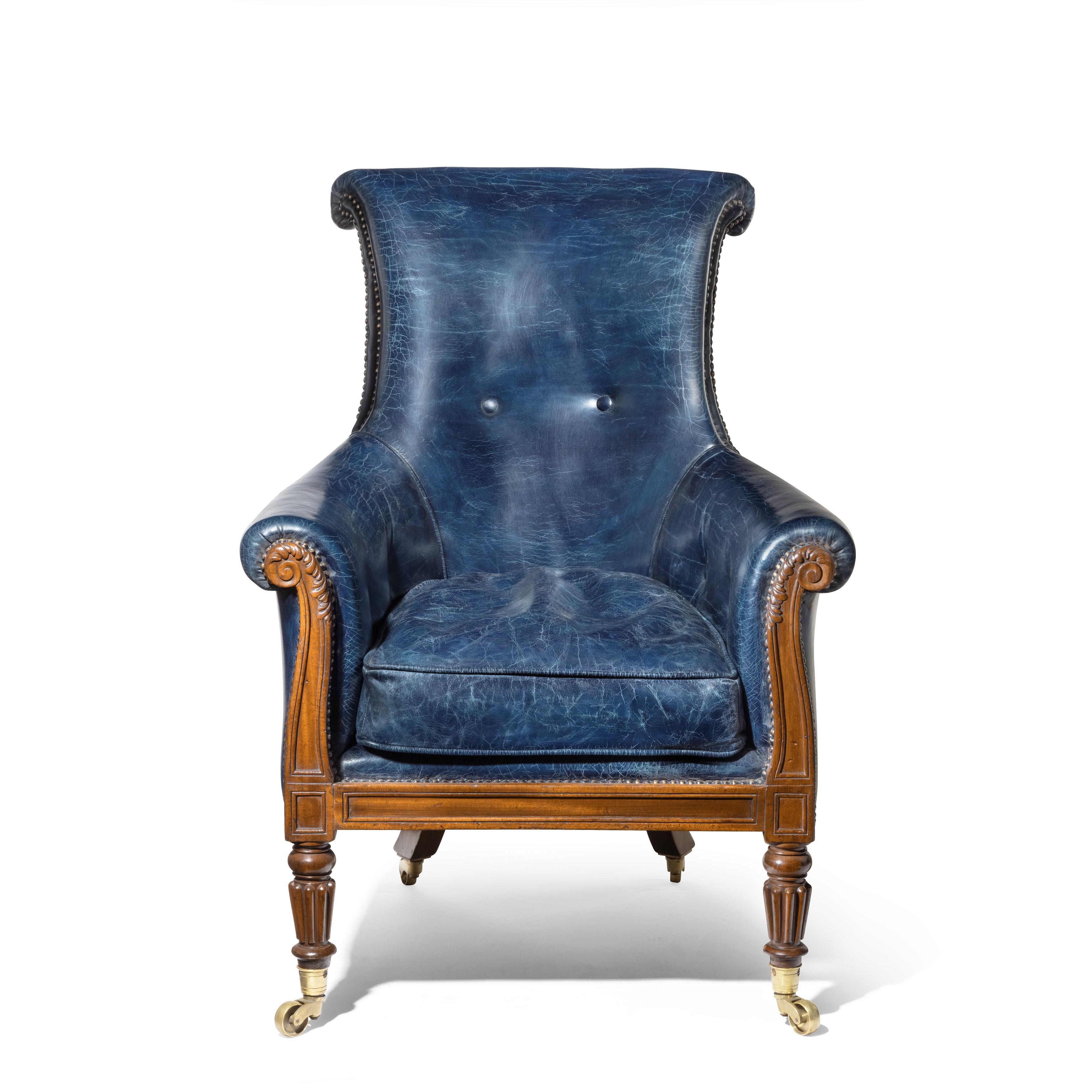 A Regency mahogany library chair by Gillows, the slender, shaped scroll back integral with the acanthus-carved scroll arms, the panelled seat rail set upon turned and reeded front legs and outswept back legs with similar decoration, all with brass