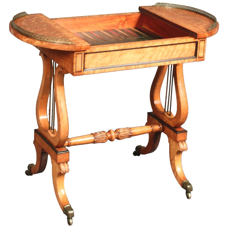 A Regency maplewood lyre-end games table. The top reverses to show either a plain surface or a chessboard and removes to reveal a backgammon board. Gallery 3/4