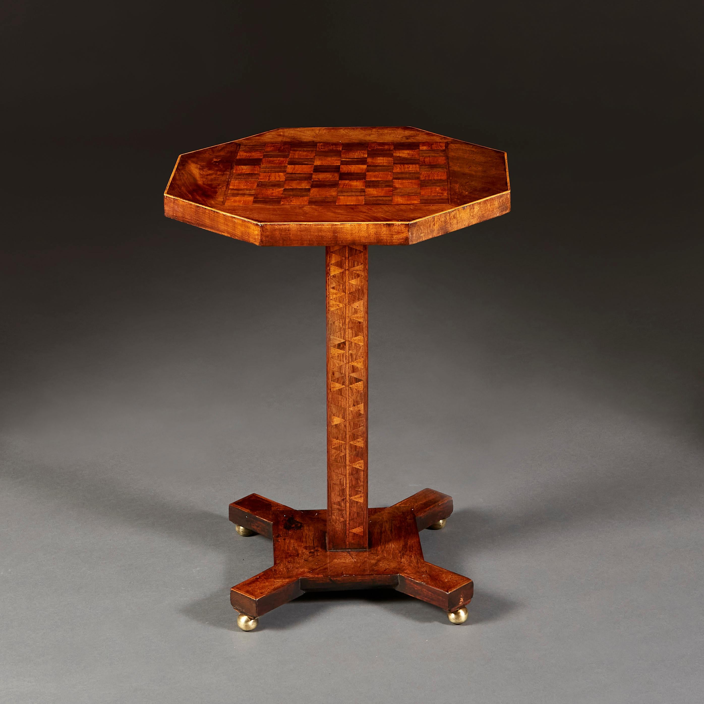 A fine Regency mahogany and fruitwood occasional table with octagonal top with inlaid chessboard, the pedestal with chevron marquetry throughout, all supported on a quadruped base with brass bun feet.