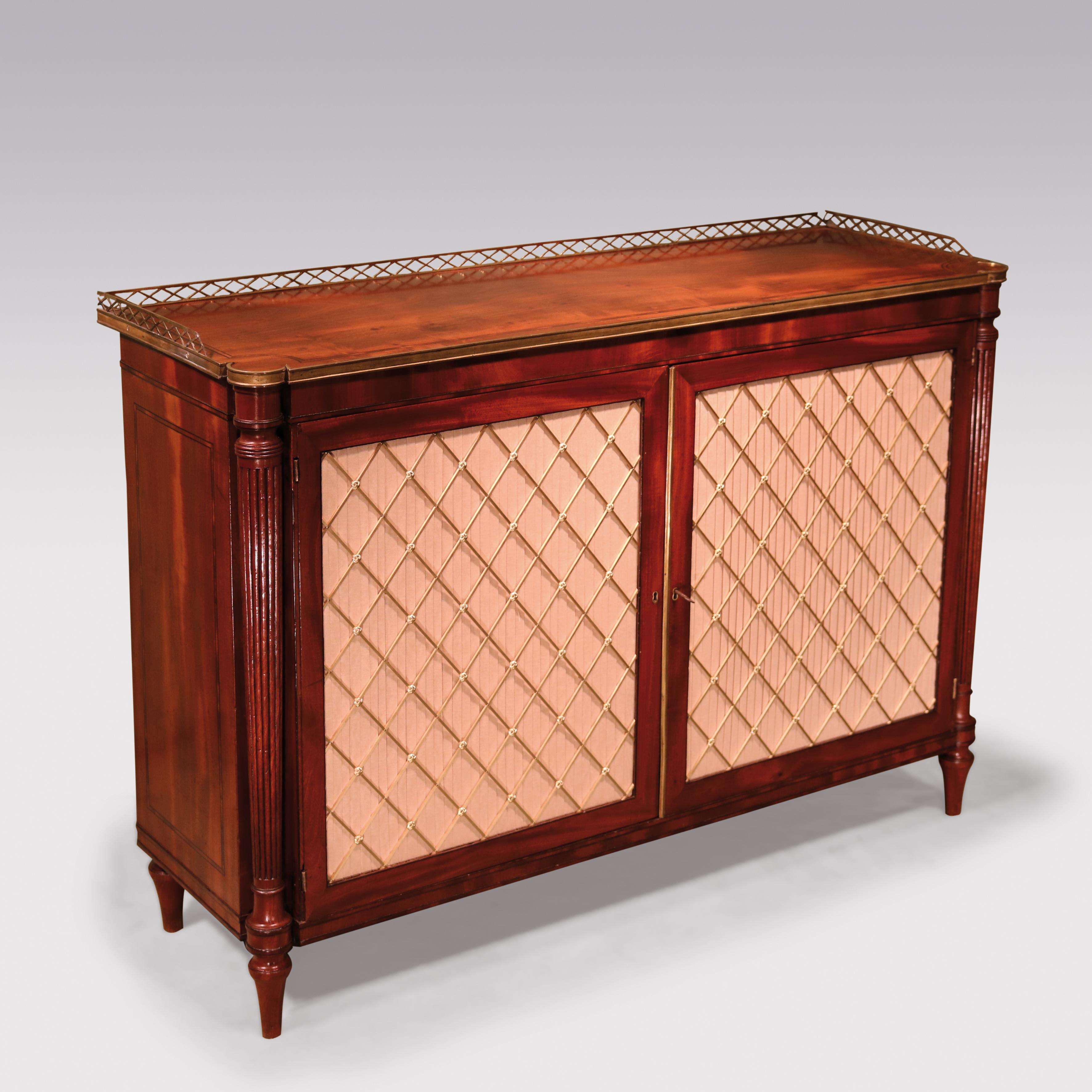 A fine early 19th century Regency period Mahogany 2 door cabinet having crossbanded and brass galleried rectangular lobed top with brass edging above brass grille pleated panelled doors flanked by turned reeded columns. The Cabinet with crossbanded