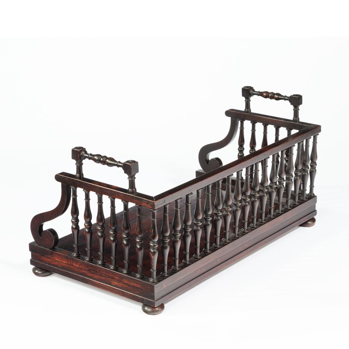 Un plateau à livres en bois de rose de style Régence, vers 1815, attribué à Gillows, la galerie de trois quarts en fuseau tourné incorporant une paire de poignées percées, au-dessus de la plinthe en bois de rose et des pieds en forme de chignon
