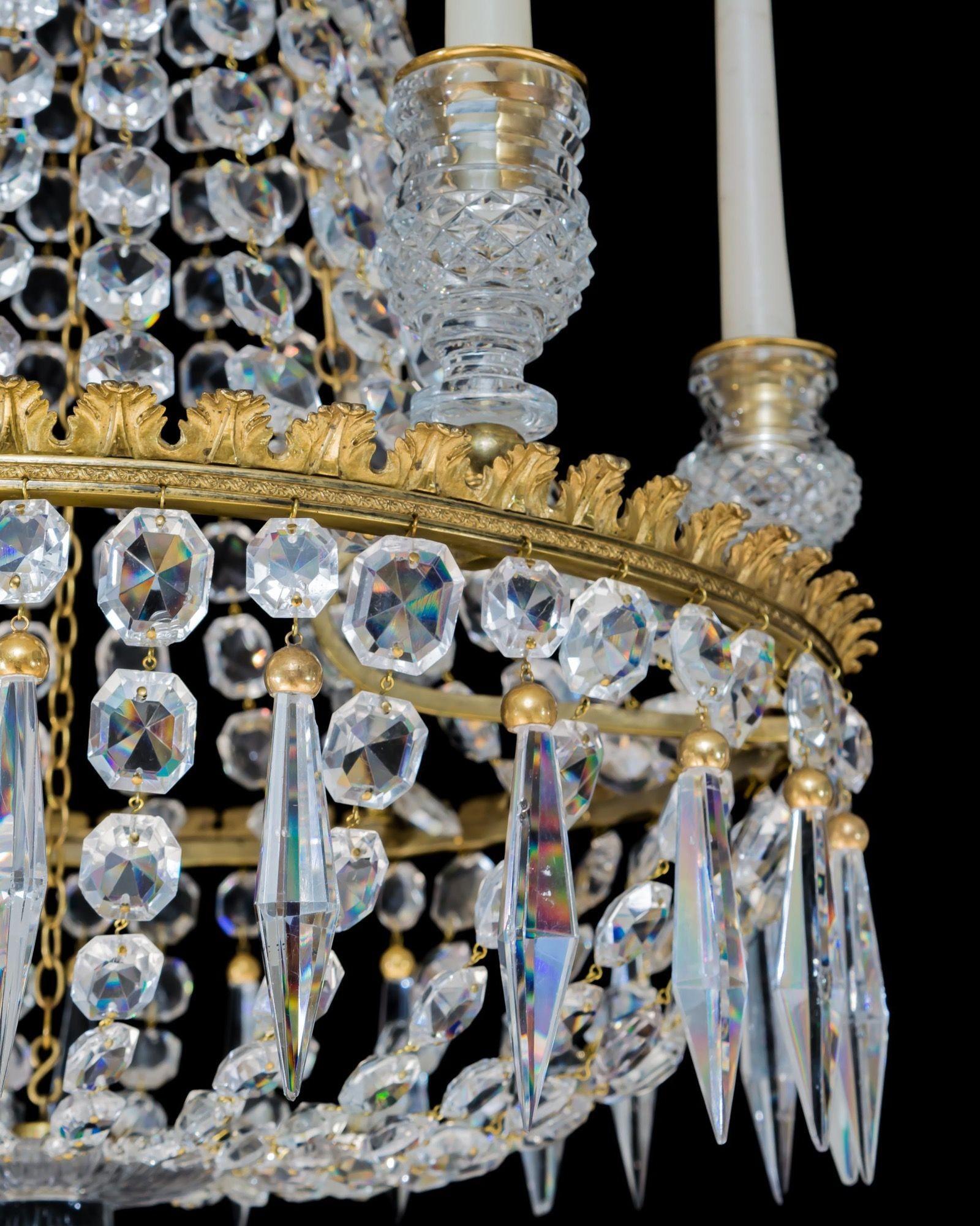 The chandelier of classic tent and basket design, with drop hung canopy supporting graduating spangles cascading to the main foliated band, supporting six diamond cut candle nozzles, the chandelier hung with ormolu capped triangular icicles and