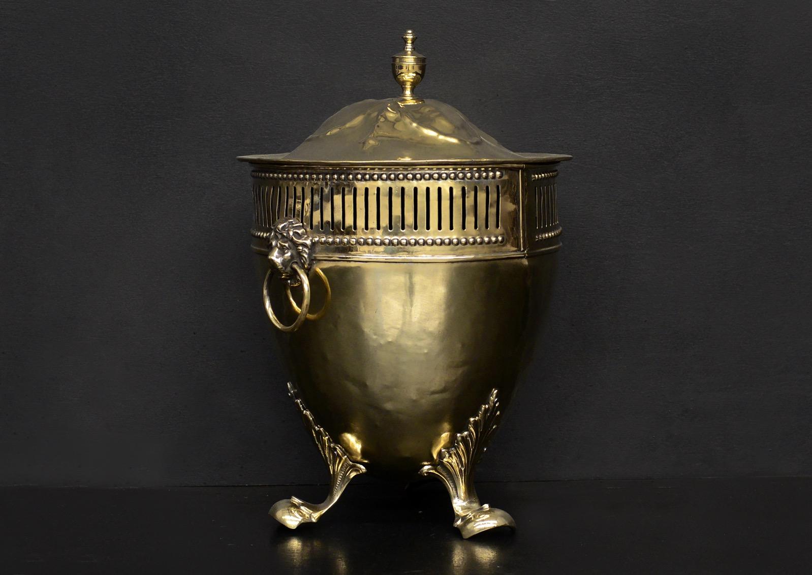A 19th century brass coal bucket in the Regency manner. The decorative feet surmounted by urn shaped body with flutes, beading, lion's masks, ring handles. The top with finely cast urn finial. English.

Height:	483 mm      	19