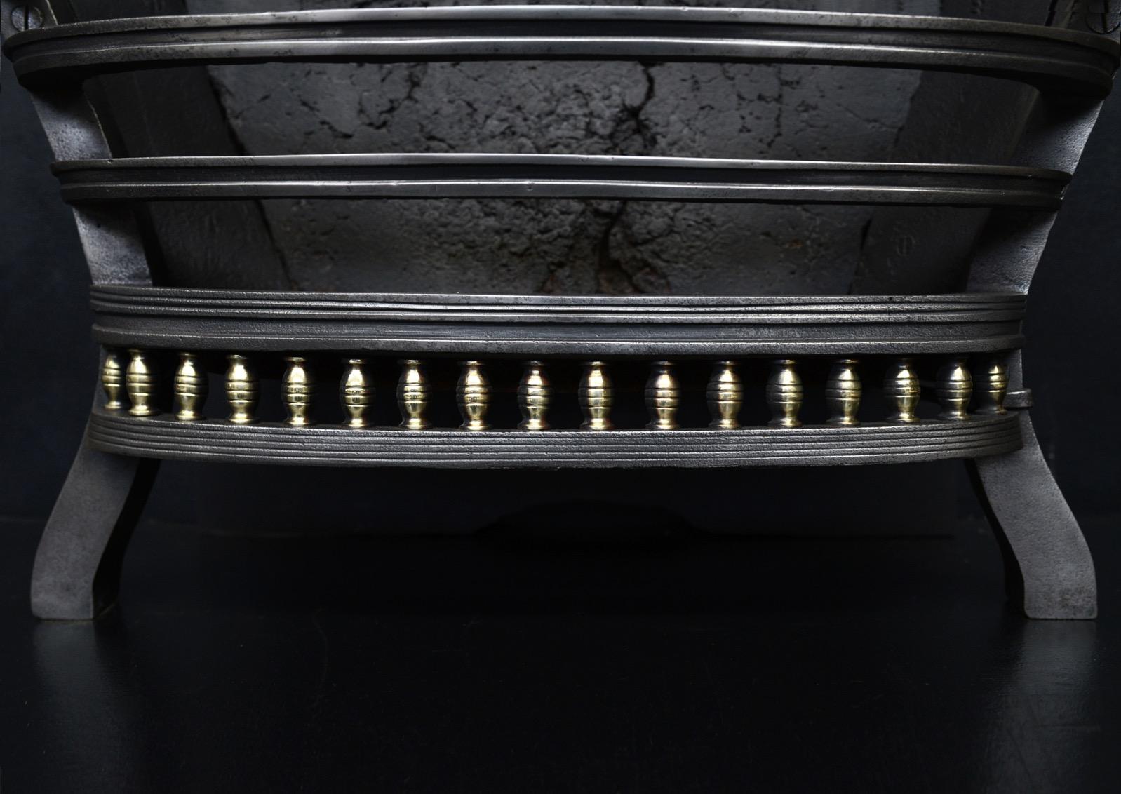 A good quality cast iron firebasket in the Regency style. The bowed front bars with brass uprights below and shaped feet. The cast iron pedimented back with ball finial to centre. English, 19th century.

Width At Front:	625 mm      	24 ⅝
