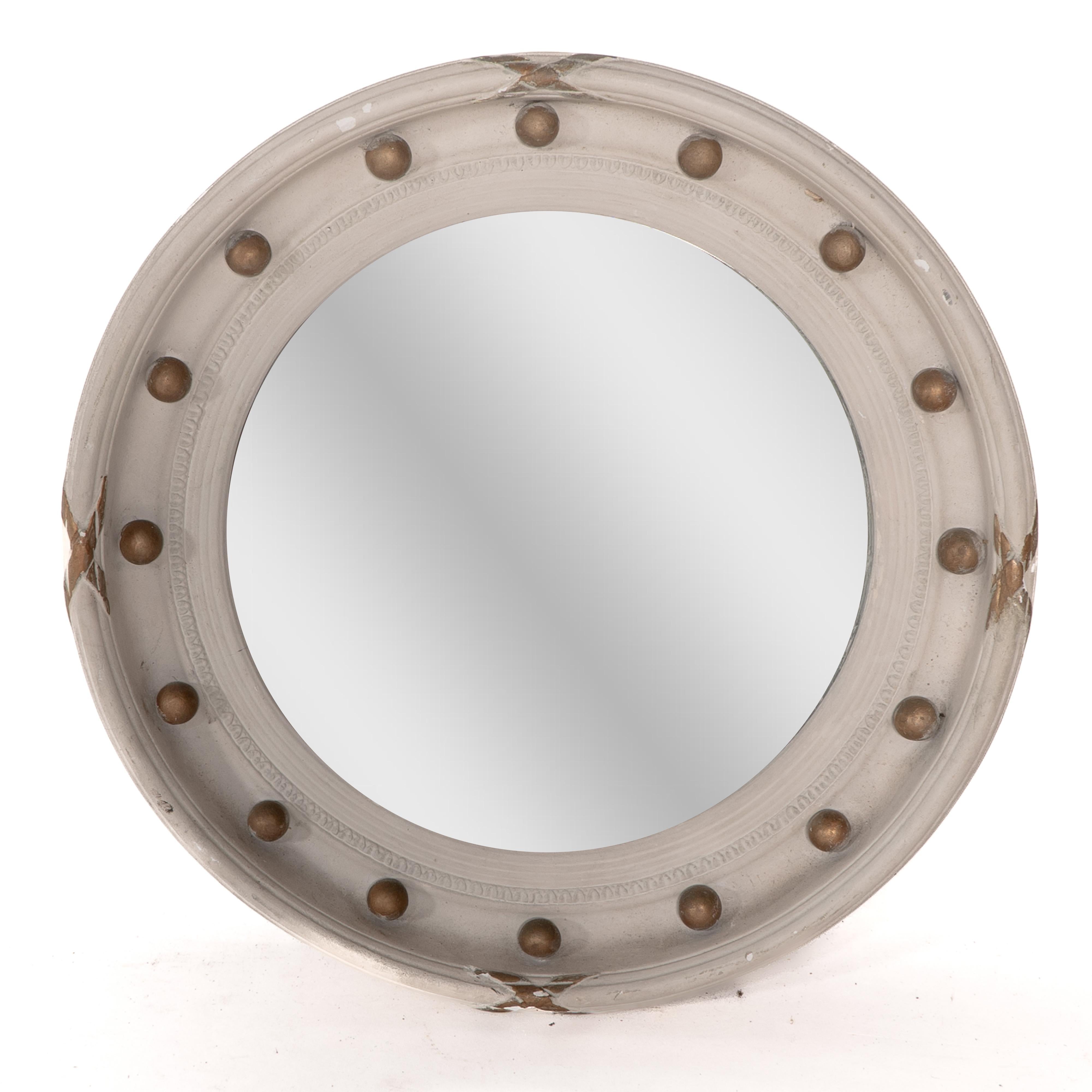A Regency style circular convex mirror with ball and ribbon decoration.