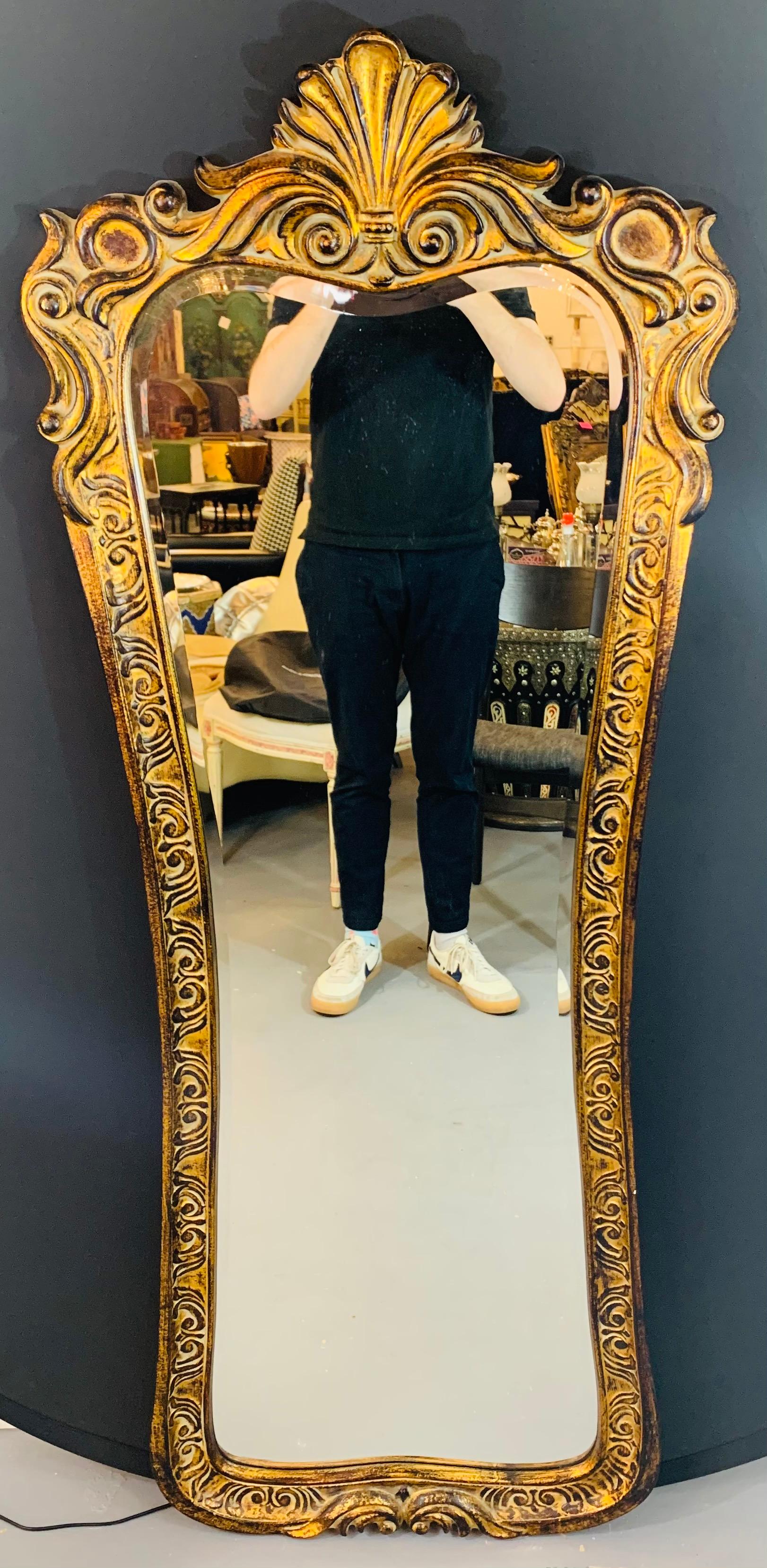 A stylish and elegant tall wall or depressing mirror in Regency style. The mirror is beautifully hand carved of gilded antiqued wood. Elevate your bedroom, walk in closet or dressing room style with this lovely mirror. 

Dimensions: 23