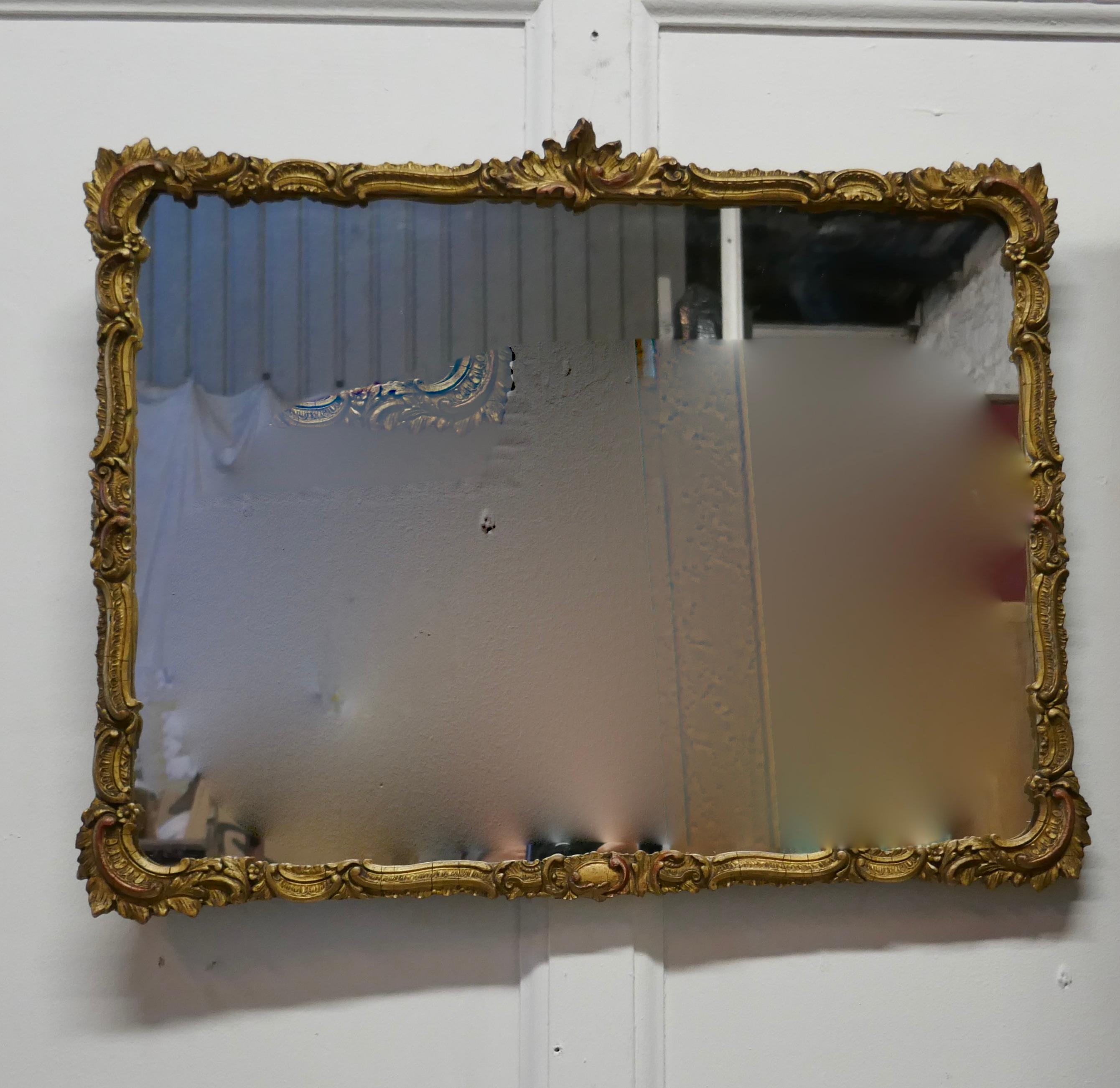 A Regency style gilt wall mirror

The rose gilt frame has a Rococo shell decoration all the way around the rectangular frame
The mirror is in good condition there are very minor cracks in the gesso but is all stabile
The mirror is 18” high and