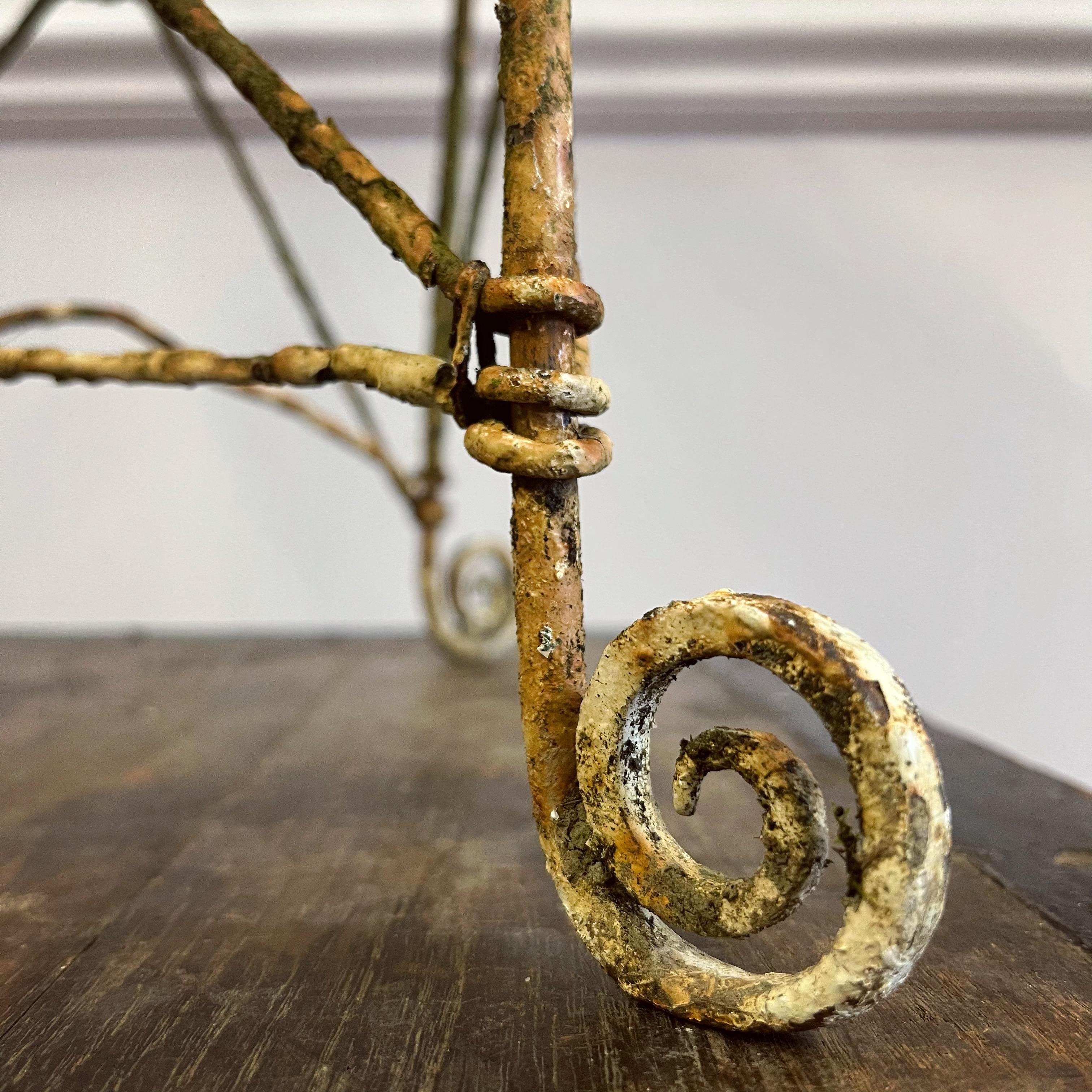 Elegante silla de jardín de alambre de la Regencia, con respaldo arqueado de tela de araña sobre paneles de diagonales, debajo hay un asiento circular de muchos círculos concéntricos.

Inglés, principios del siglo XIX

Alto 96 x Ancho 42,5 x Fondo