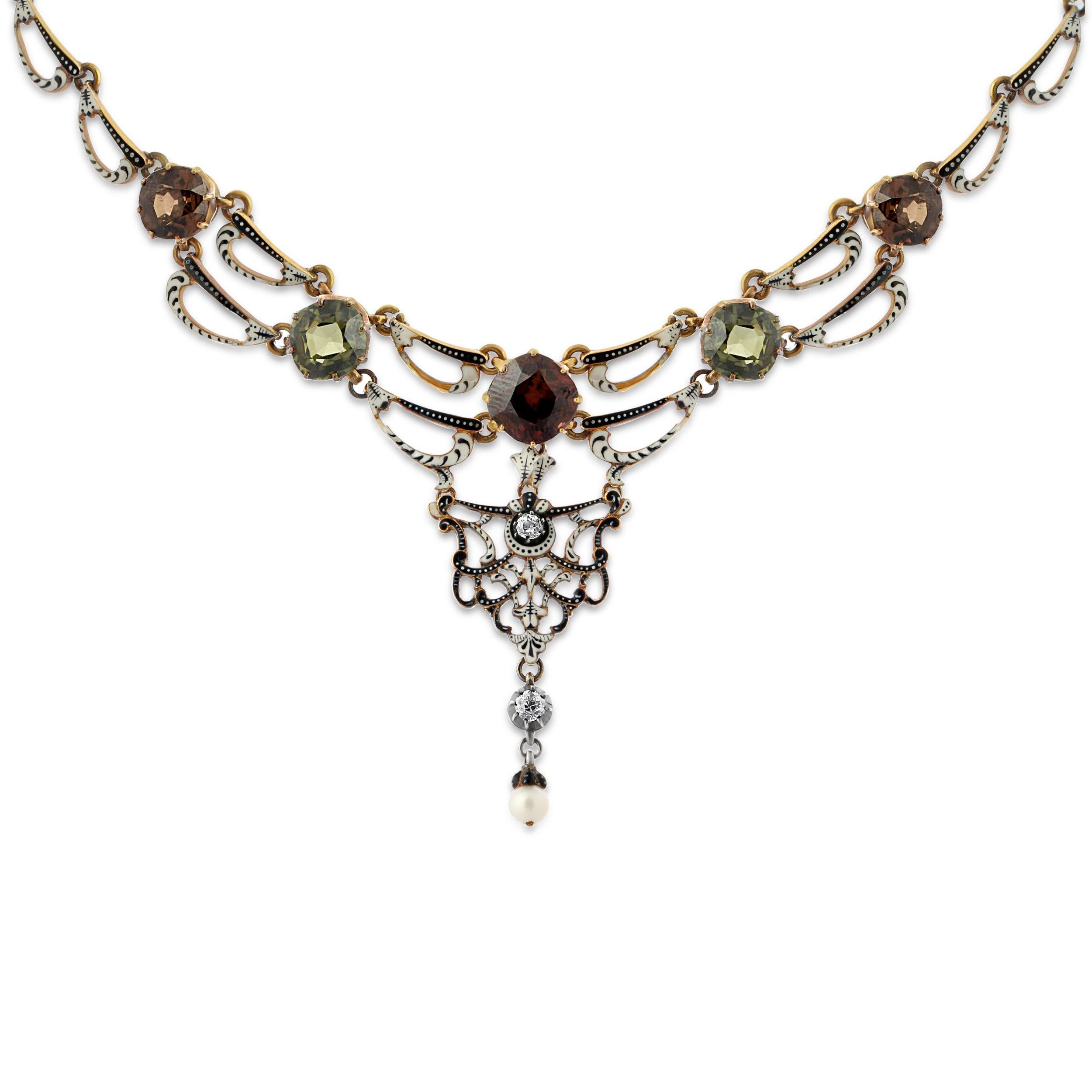 A renaissance revival gold, enamel and gem set necklace by Carlo Giuliano. A stunning openwork scroll design with black and white enamel details mounted on gold with five green and orange-brown cushion-cut zircons. The central drop is set with