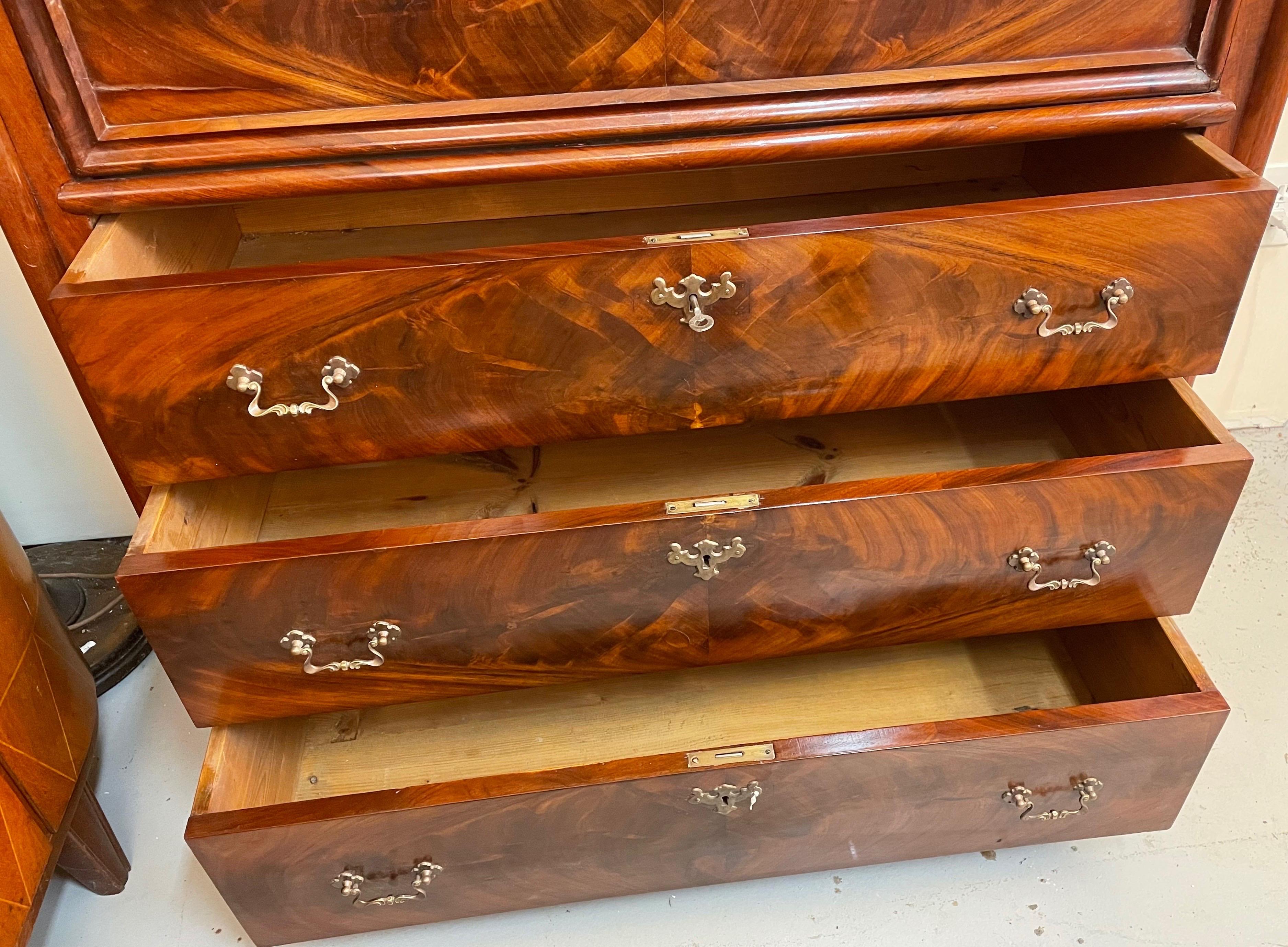 Los detalles del diseño indican que este secretario se fabricó a finales del periodo Biedermeier, cuando floreció el interés por los periodos históricos. El cajón superior está curvado en el clásico diseño Biedermeier/Louis Philippe, favorecido