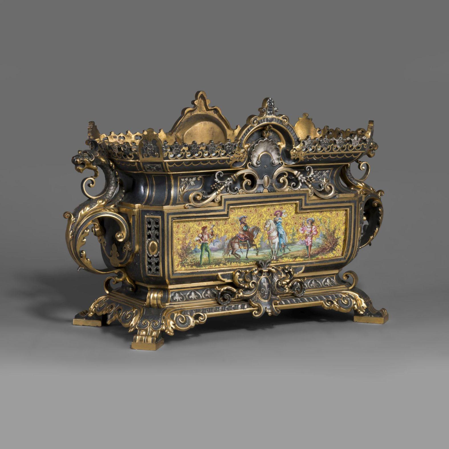 An important and very rare renaissance style porcelain mounted jardinière.

This striking jardinière cast in gilded, silvered and patinated bronze with acanthus and chimeras is mounted with finely painted porcelain plaques depicting a falconry