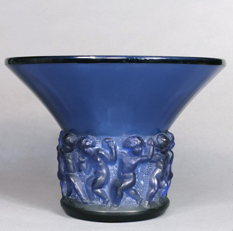 The farandole vase was made by R.Lalique in 1930 in white glass.

This example is in Lalique's famous deep blue glass , called French blue in opposition with the blue electric color of Lalique.

The Farandole vase is a real study of the famous