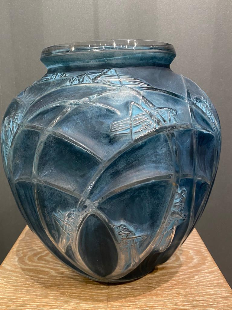 R.Lalique is world known for his opalescent and colored glass creations.

Some of his very first pieces are in white glass with a double colored patina like this Criquet vase which was designed in 1912.

The background is deep blue as the