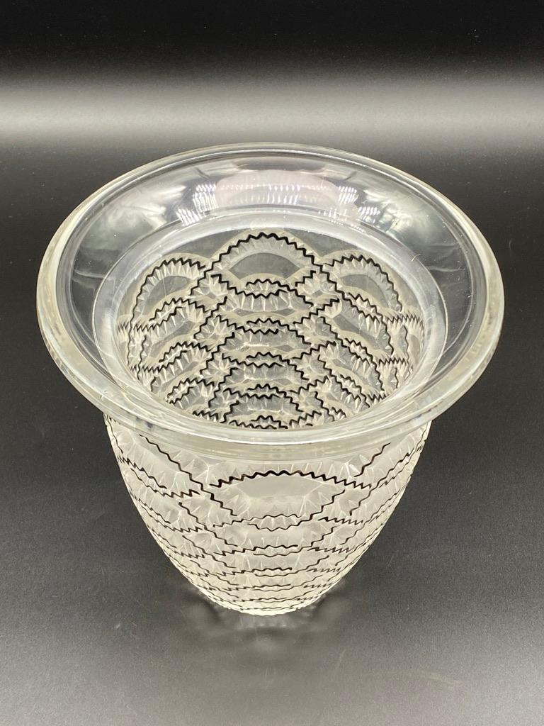 Le vase guirlandes a été créé en 1935 par R.Lalique en verre blanc.

L'édition de luxe du vase est émaillée sur le décor.

La société Lalique s'était spécialisée dans la production de son verre.  production en différentes couleurs, patines et