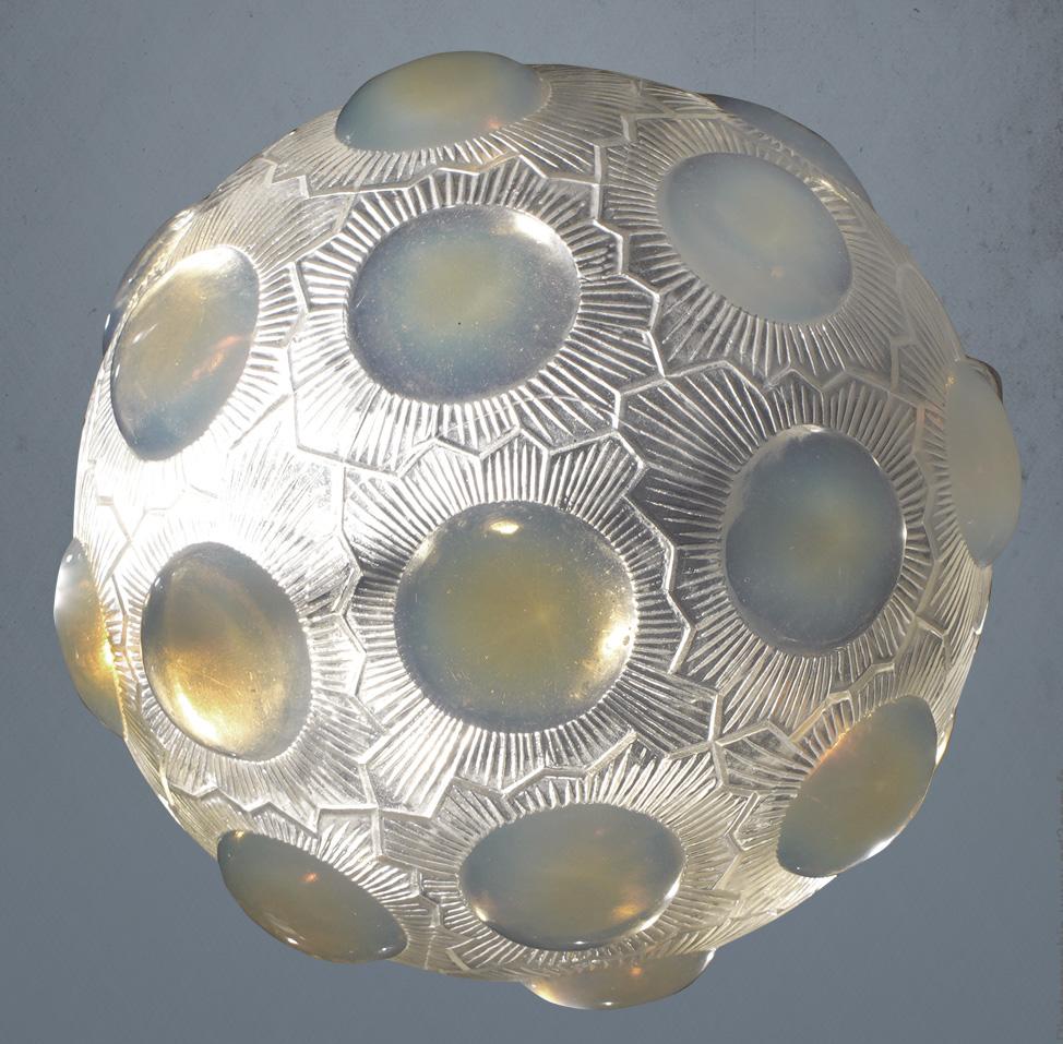 A strong Art Deco and iconic   design of R.Lalique known as the Soleil Chandelier.

This piece is made in opalescent glass with a yellow shine on it.

The ropes, the cache béliere are genuine and belong to the chandelier.

The electric system is