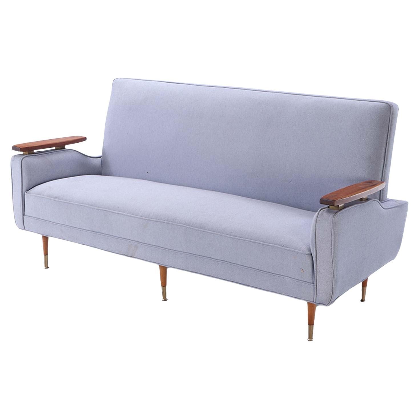 A restored sofa with floating wood arms and metal mounts circa 1960.