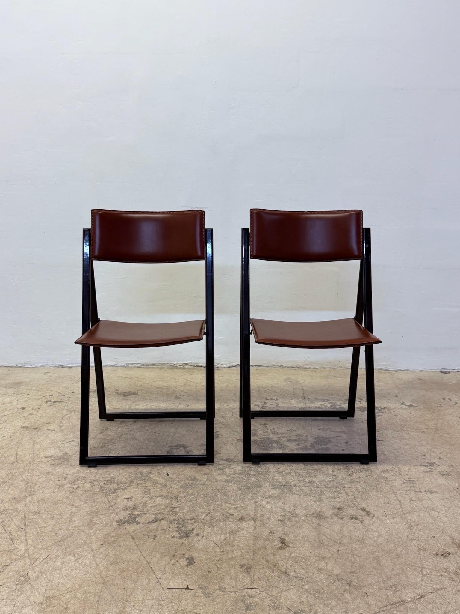 Pair of Garina leather folding side, dining or game table chairs by A. Riccardi & Giorgio Salvini for Matteo Grassi, 1970s.