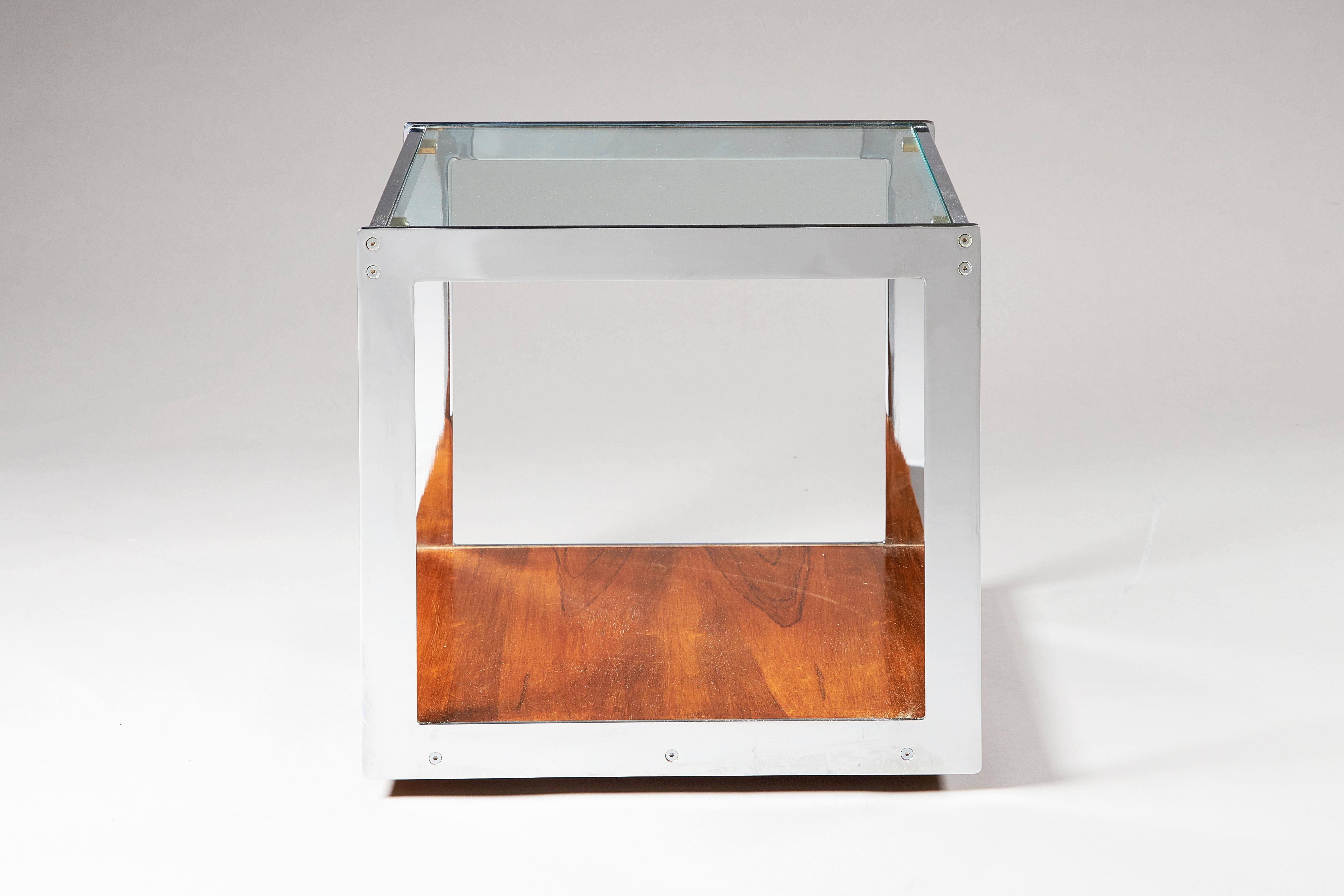 A 1970s chromed steel, glass and rosewood side table. Designed by Richard Young for Merrow Associates, with glass top and rosewood lower shelf, on wheels. Comes with A10/CITES documentation.
  