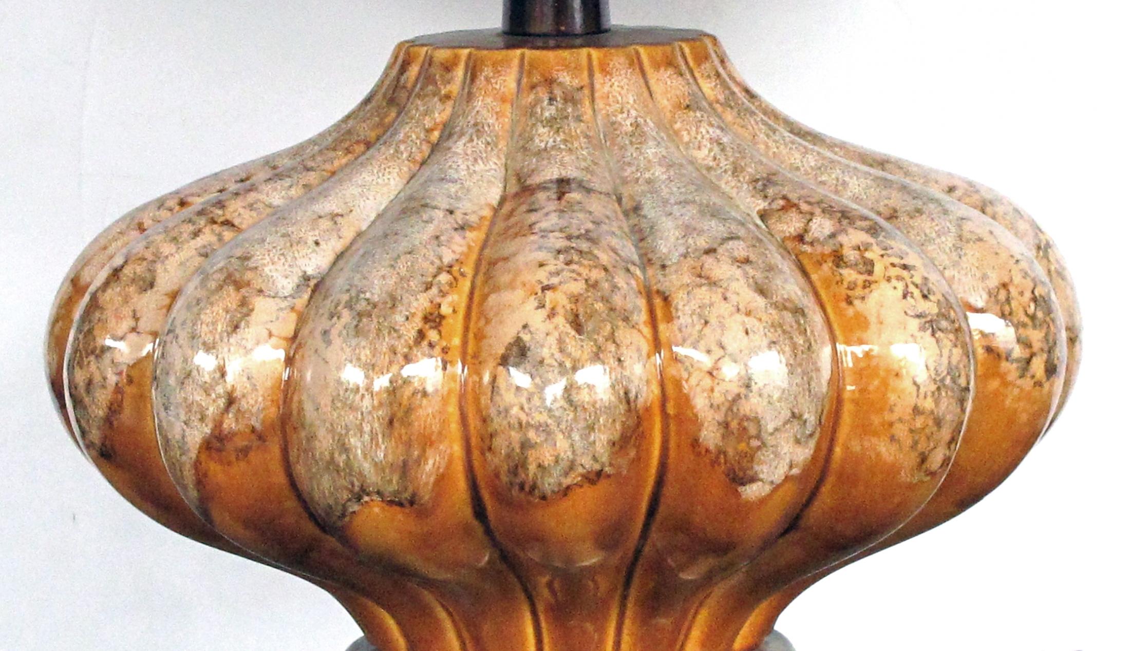 of compressed form covered overall in an ivory and brown drip-glaze over a caramel ground