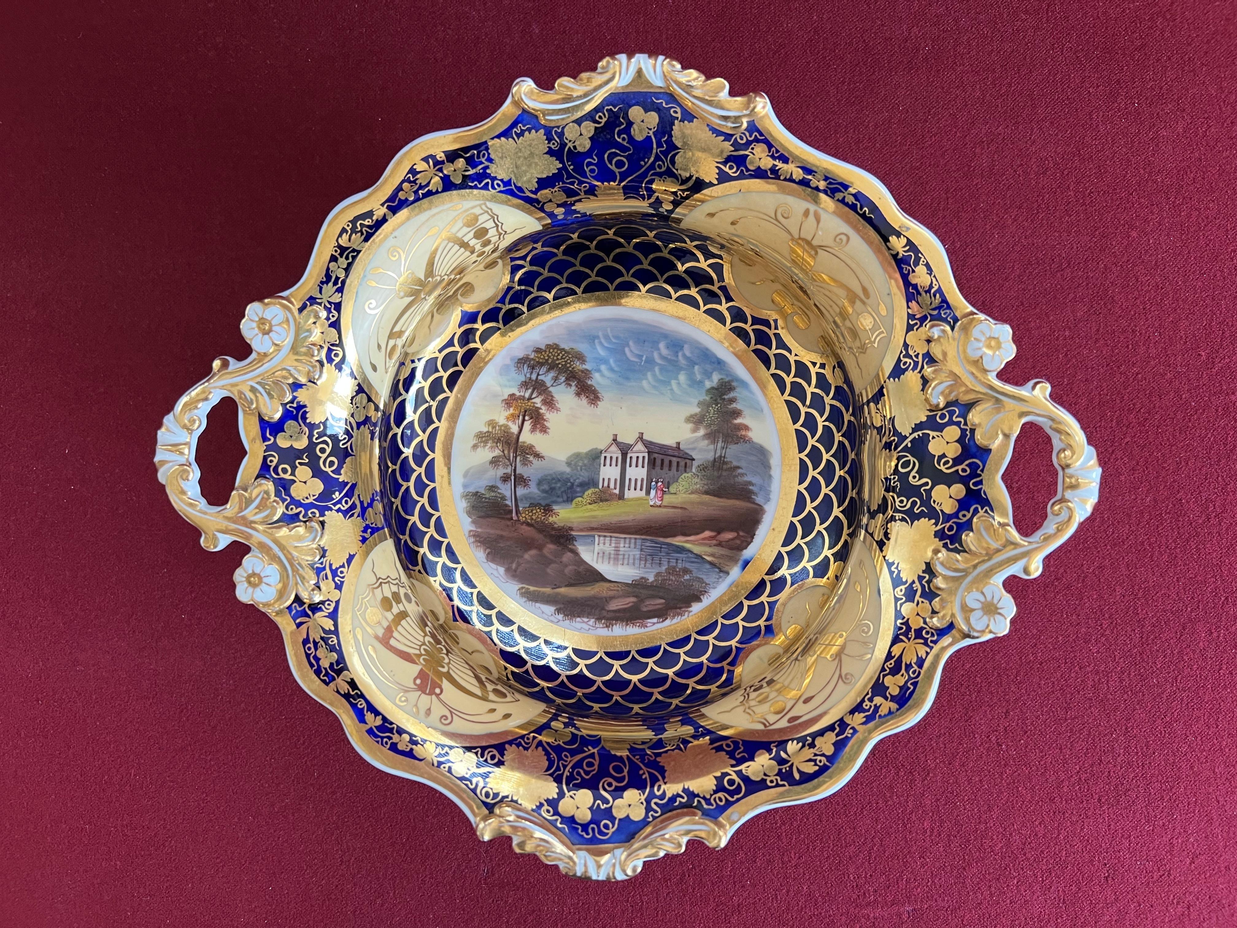 Un service à dessert en porcelaine finement décoré de John & William Ridgway, modèle 1045, c.1825. Le puits central de chaque pièce est décoré d'une scène de ruines / d'un château / d'une maison ou d'un cottage dans un paysage, avec un fond bleu