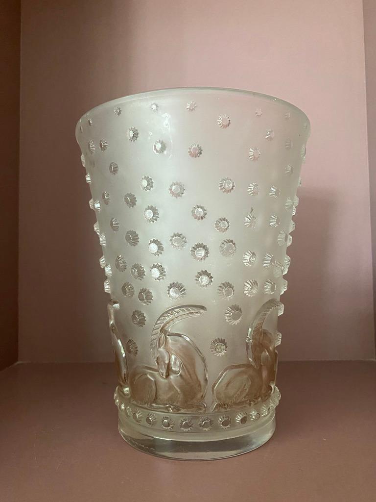 The vase Ajaccio vase is a strong Art Deco designed vase dating back to 1938in white glass.

The vase is decorated with stars and deers .

The deers have kept a brown patina .

The vase is in excellent condition and signed R.Lalique in  sand blasted
