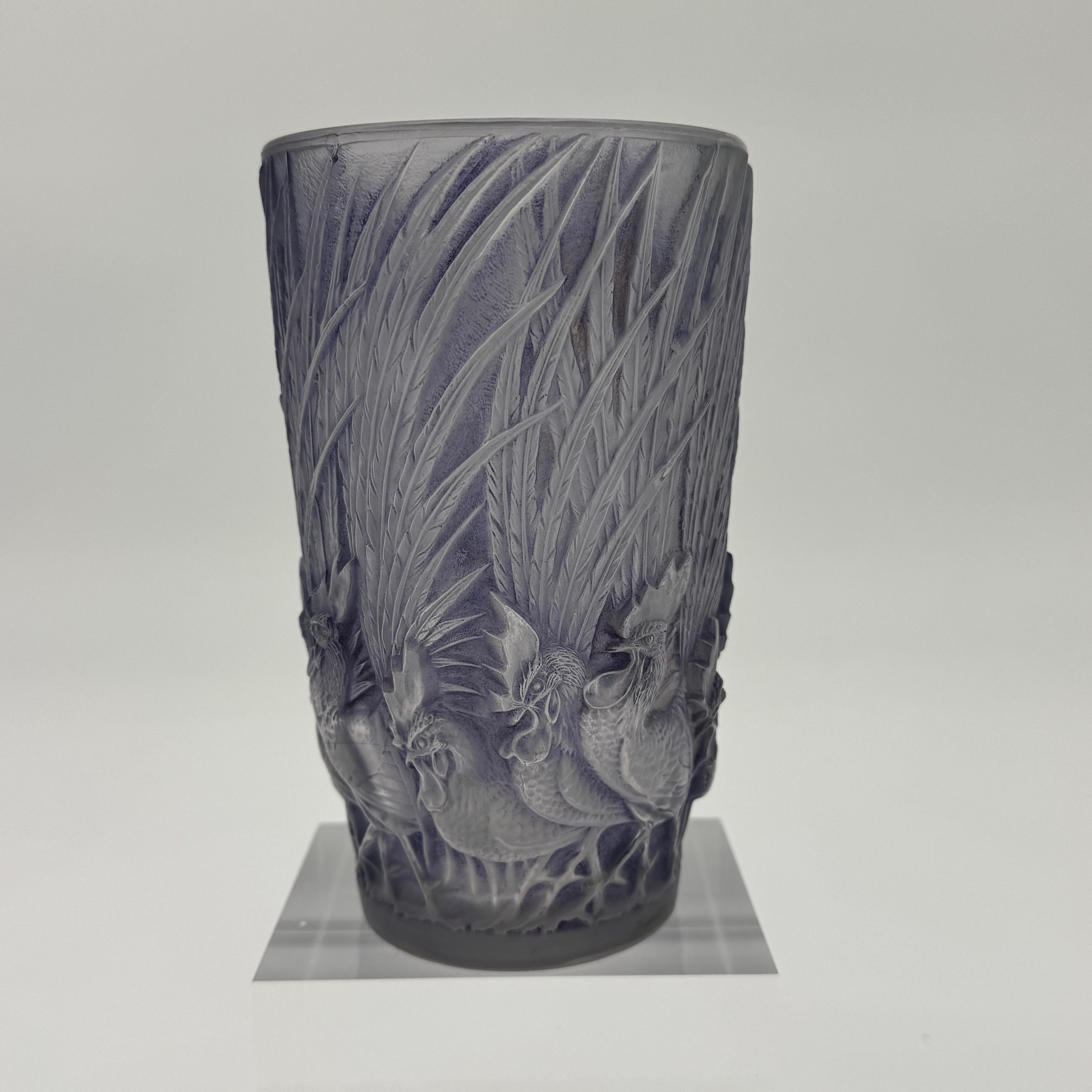 The Coqs  and Plumes vase was created by R.Lalique in 1928 in white glass.

This example is in white and violet patinated glass and un excellent condition.

The vase is signed R.Lalique France in sand blasted block letters .