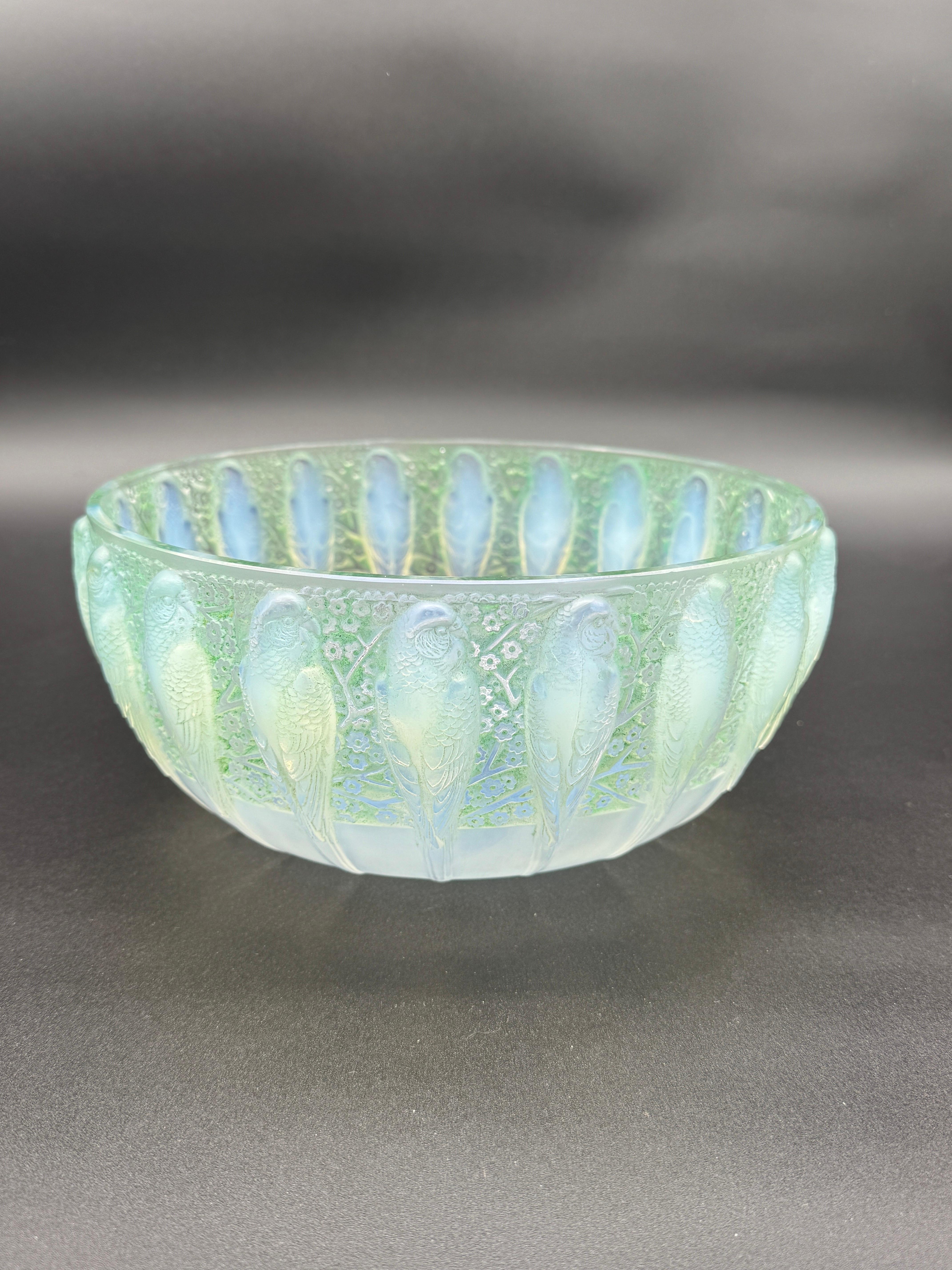 La ciotola Perruches è uno degli oggetti più desiderati di R.Lalique.

La ciotola è circondata da pappagalli che spuntano su un fondo patinato verde fiori.

La ciotola è in vetro opalescente e firmata a caratteri cubitali sabbiati.

La spedizione è