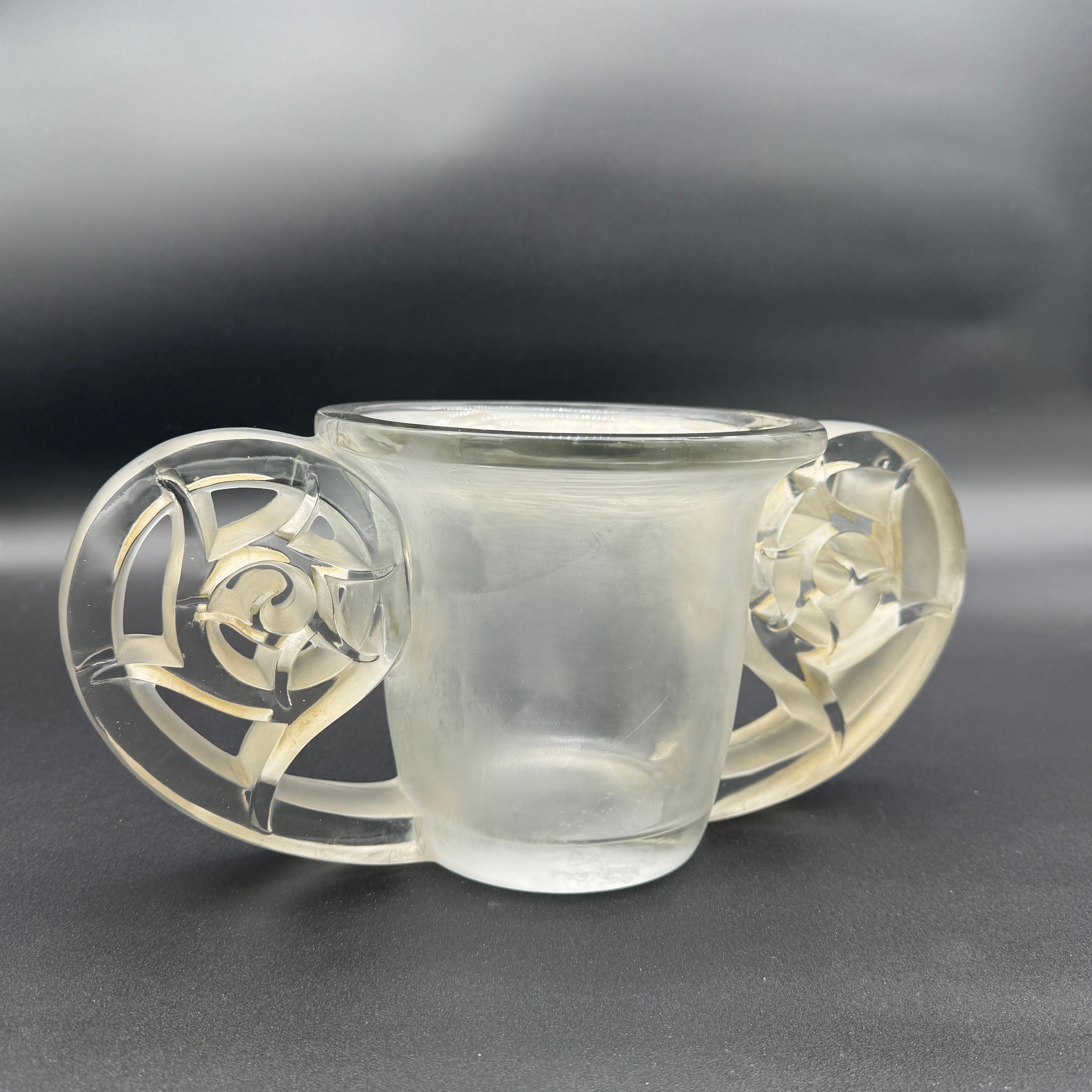 Der Pierrefonds wurde gegründet  1926 aus weißem Glas von R. Lalique.
Das Design ist stark von der aufkommenden Art Déco-Epoche beeinflusst.
Die Vase ist 33 cm breit und 15,5 cm hoch.

Die Signatur ist in Blockbuchstaben handgeschnitzt.