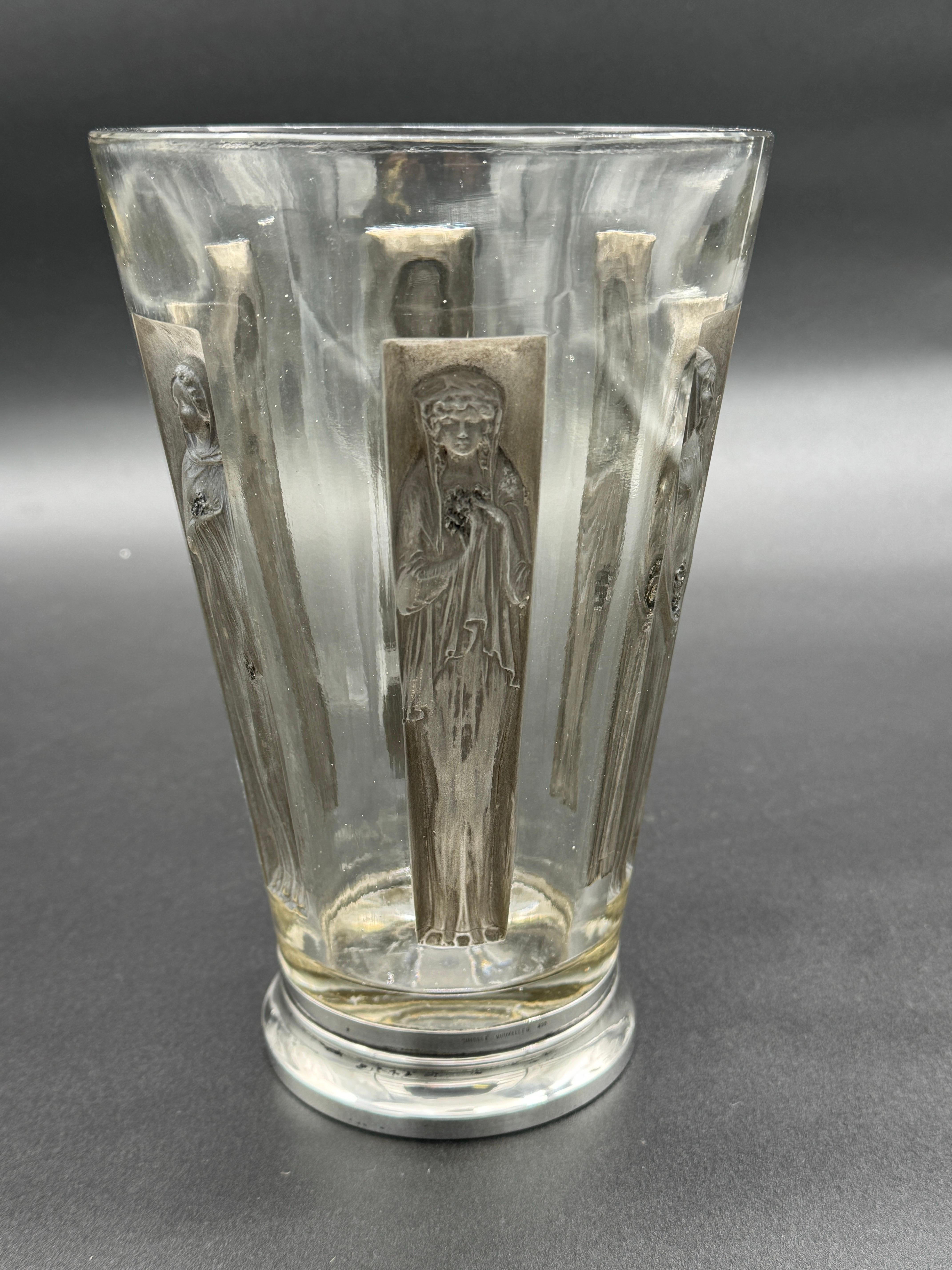 Il vaso 6 Figurine è stato creato nel 1911 da R.Lalique in vetro bianco.

Questo pezzo ha mantenuto la sua autentica patina grigio scuro ed è in ottime condizioni.

Le 6 figure sono tutte in posizioni diverse e si ispirano alle statue classiche