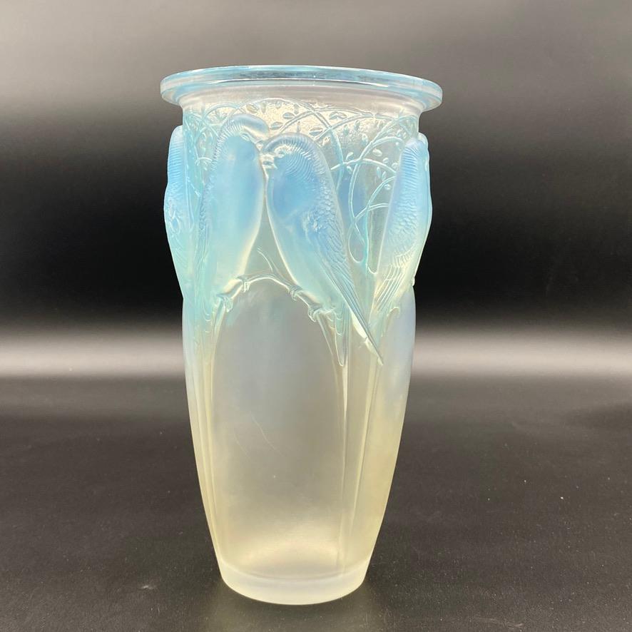 Le Ceylan a été conçu en 1924 par R.Lalique et est devenu très rapidement l'un de ses plus grands succès.

Les 8 perroquets se tiennent fièrement autour du vase.

L'opalescence et la patine ajoutent à la magie du verre.

Le vase est signé à la main