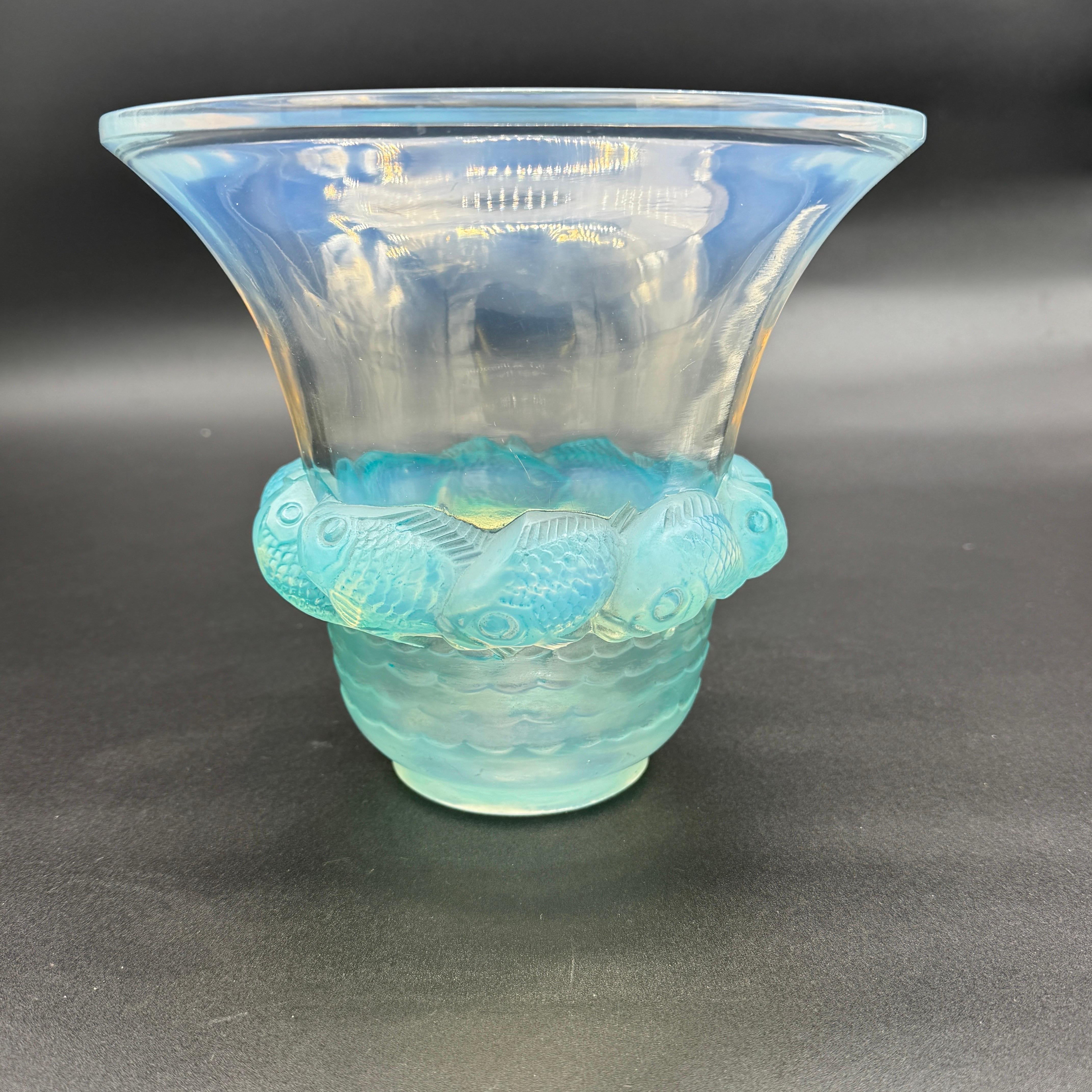 The Piriac vase was created in 1930 by R.Lalique in white glass.

This example is in strong opalescent and blue patinated glass and in excellent condition.

The signature is in script hand written letters .

The vase is 18 cm high and 20 cm wide at