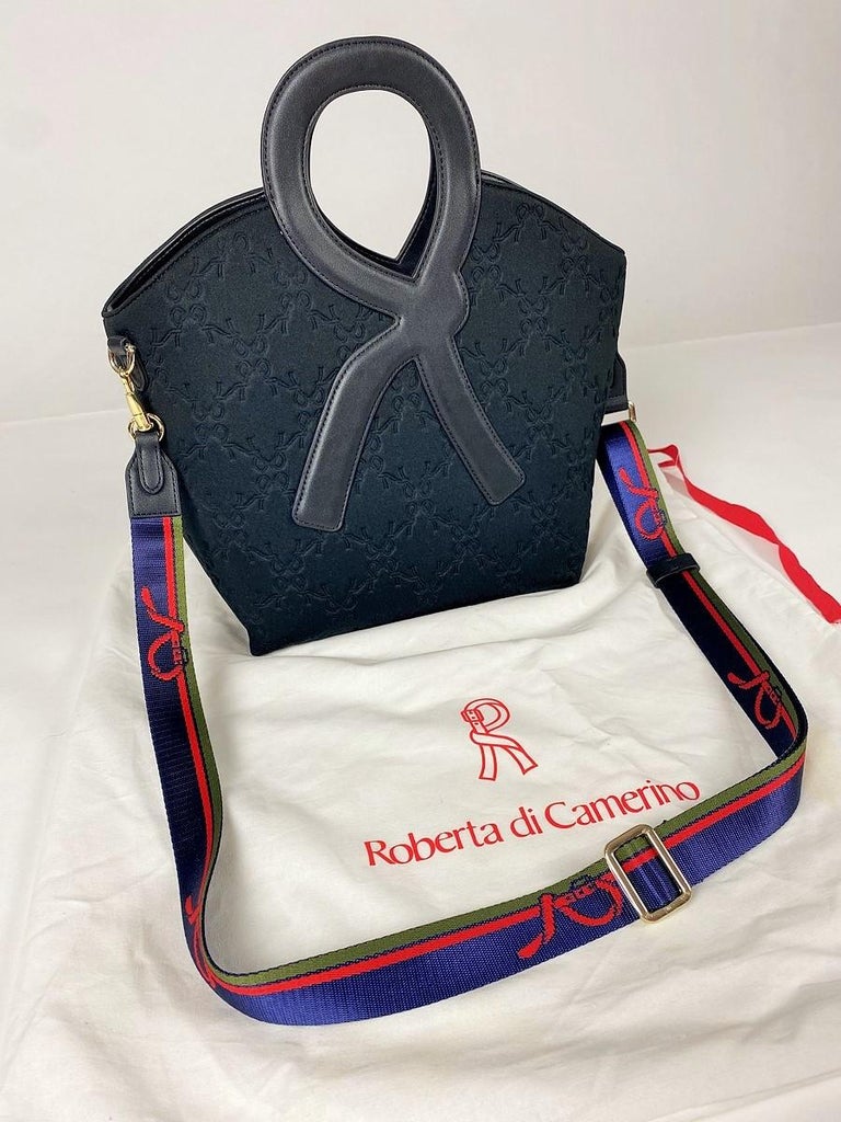 Circa 2015

Italy

Iconic handbag by Roberta di Camerino in black quilted fabric with the logo of the famous brand. Black vinyl handle and adjustable and removable shoulder strap in navy green and red with Roberta's R. Navy canvas interior with R