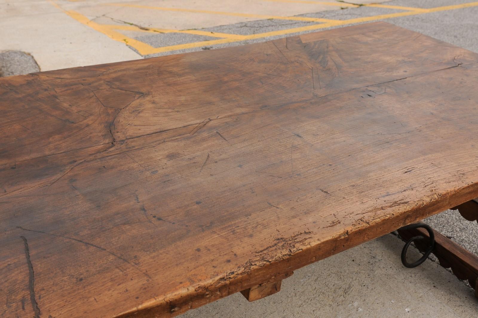 Una robusta mesa de comedor italiana de 3 metros con patas de caballete talladas y camilla de hierro Madera en venta