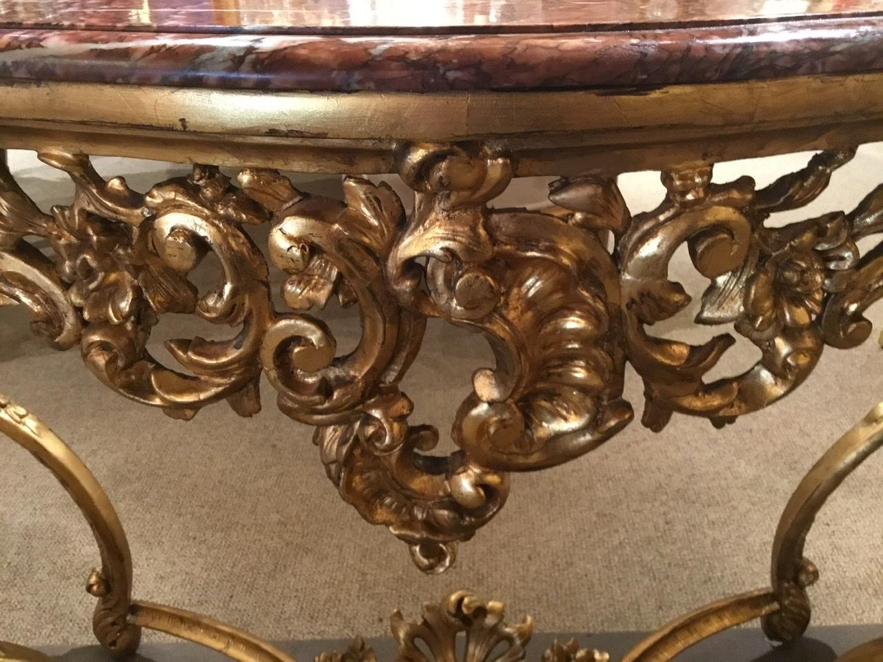 A gilt cartouche at the center front of this piece is beautifully carved with open fret work
in foliate designs and swags. Each of the four corners are curved with a floral motif
Centered on the curve of each leg. A shell cartouche and flowers are