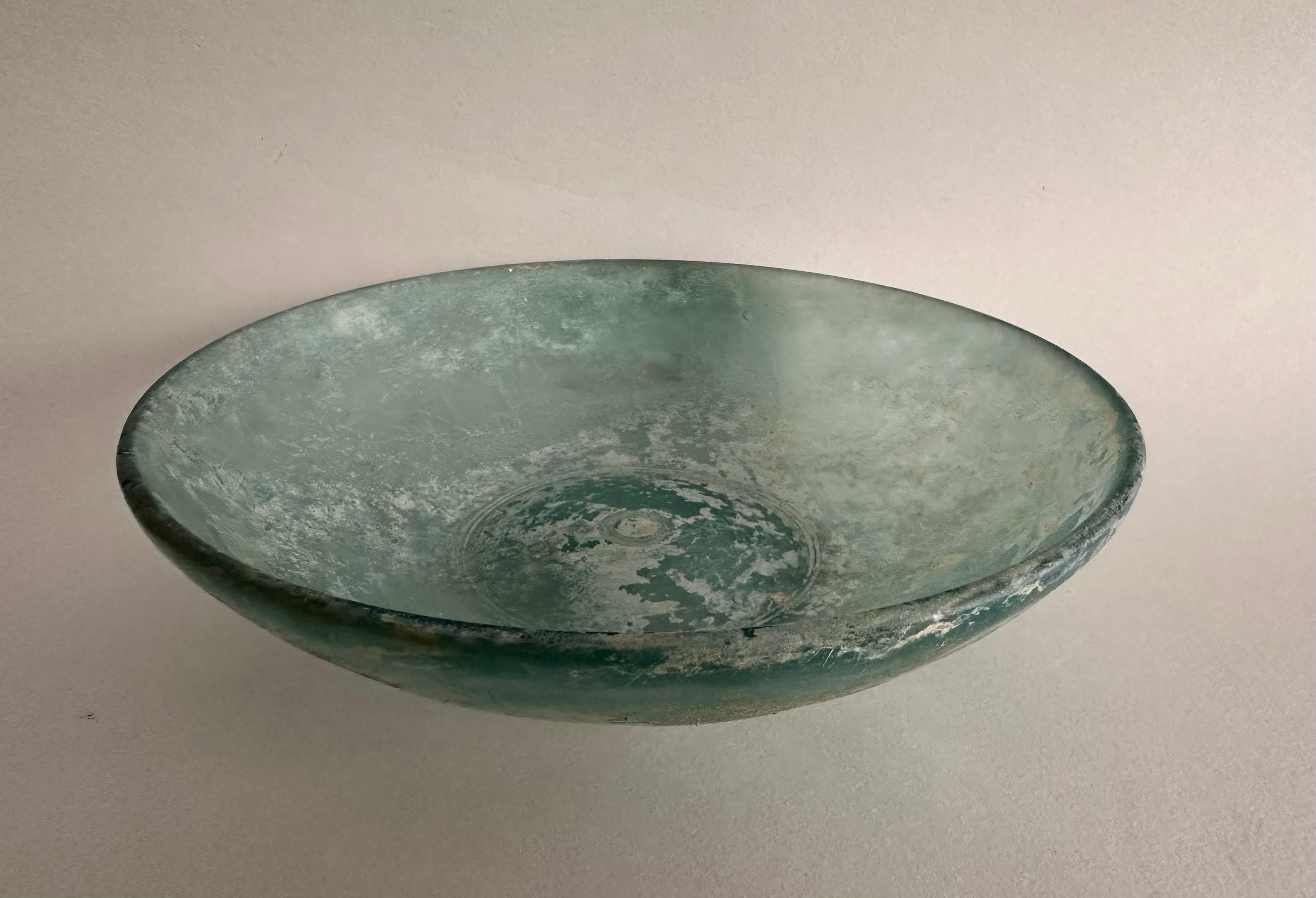 A Roman blue glass bowl,
Hellenistic period, 1st century B.C.

A blue cast glass, iridescent, engraved with two circles.

17,2 cm diameter.