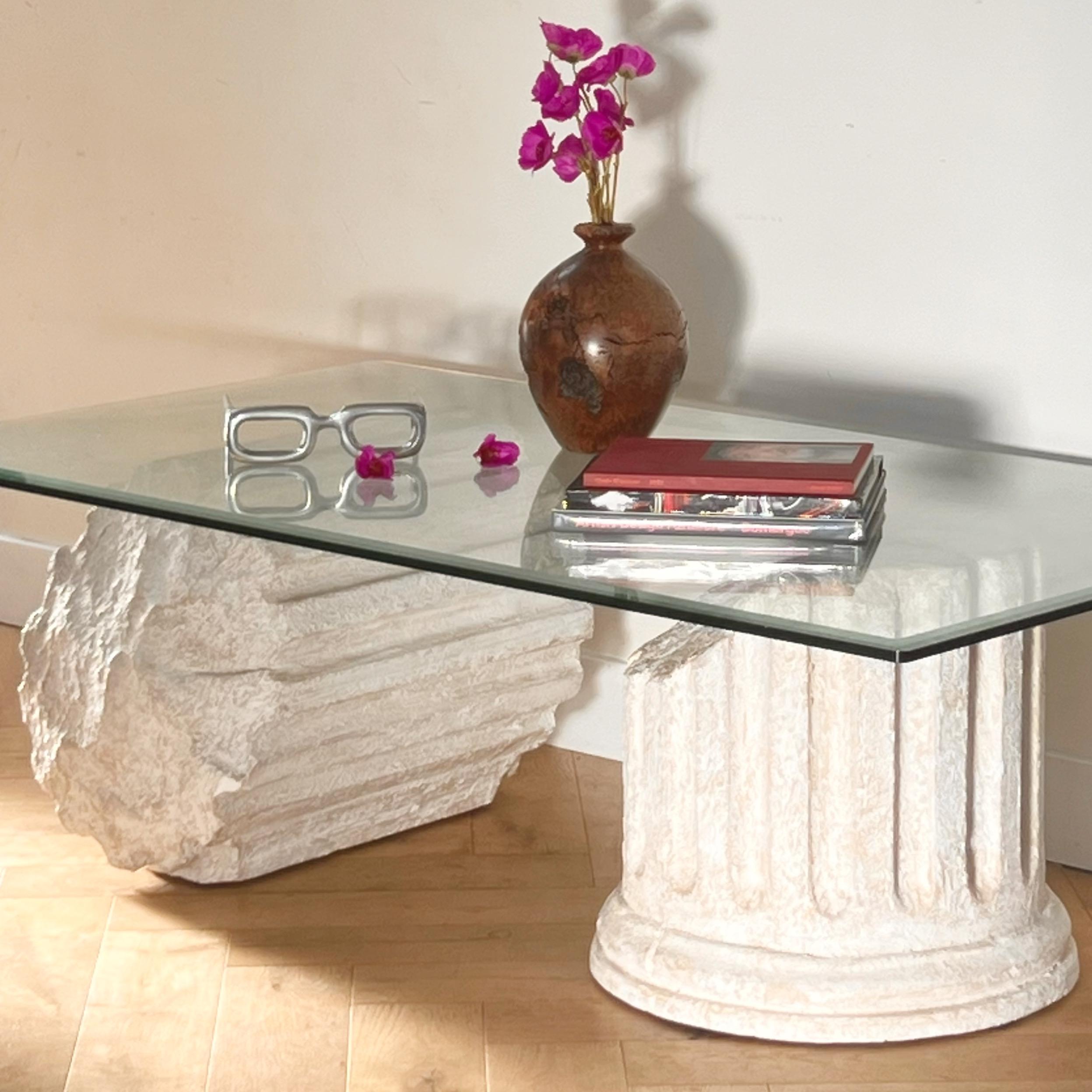A vintage postmodern neoclassical columns «ruins» coffee table after Gufram Capitello, circa late 20th century. Plaster cast Roman or Greek column ruins base upholds a beveled glass top. Great condition with minor signs of age. Pick up in central