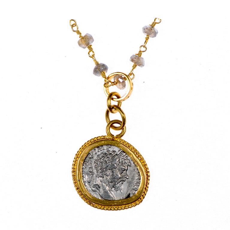 Eine authentische römische Silbermünze Severus Alexander Antoninianus (römischer Kaiser von 222 - 235 n. Chr.), eingefasst in eine 22k Goldlünette. Auf der Rückseite ist eine geflügelte Siegerin mit Schild zu Füßen abgebildet. Der Münzanhänger ist