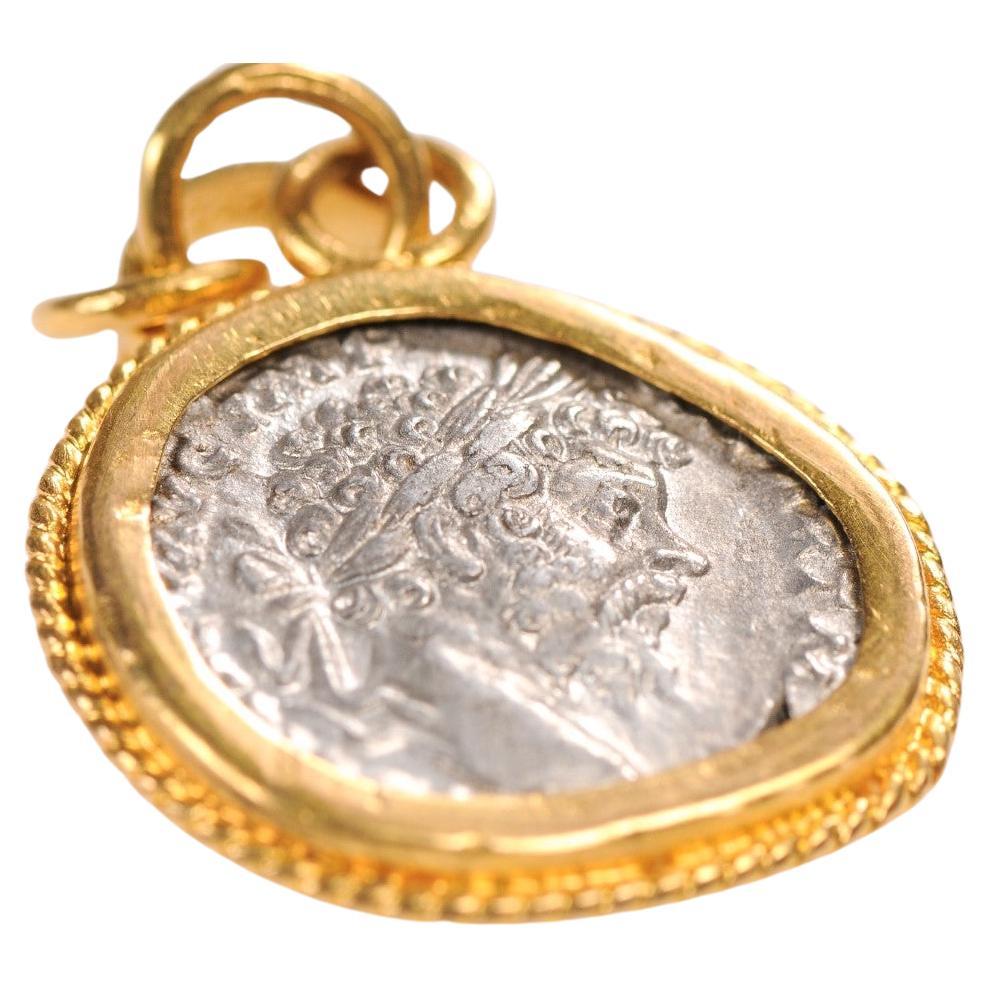Autentica moneta romana d'argento Severus Alexander Antoninianus (imperatore romano dal 222 al 235 ADS), incastonata in un castone d'oro 22k. Al rovescio, una Vittoria alata con scudo ai piedi. Il ciondolo a forma di moneta misura circa 1,5