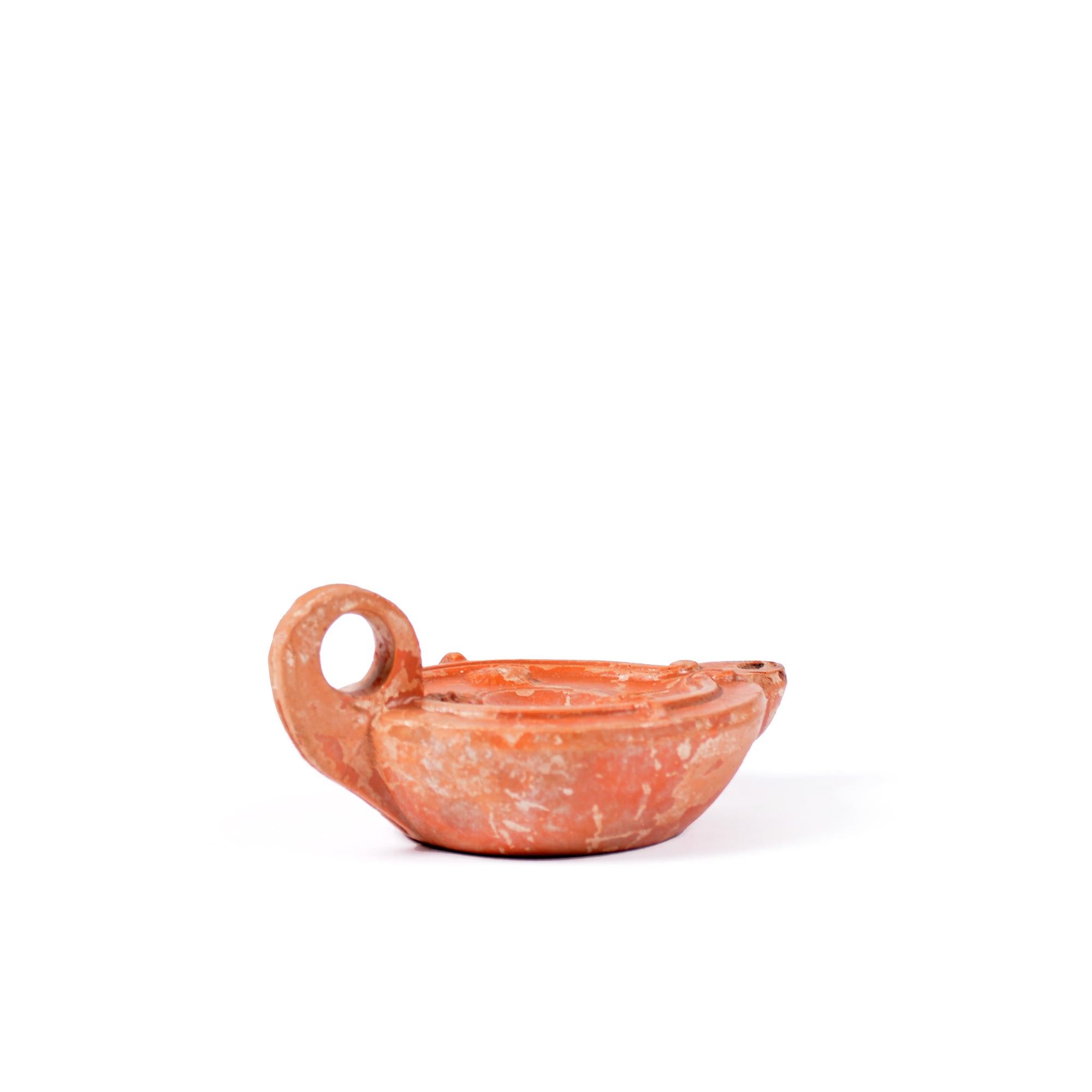 A Roman terracotta red slip ware oil lamp with theatre masks For Sale 3