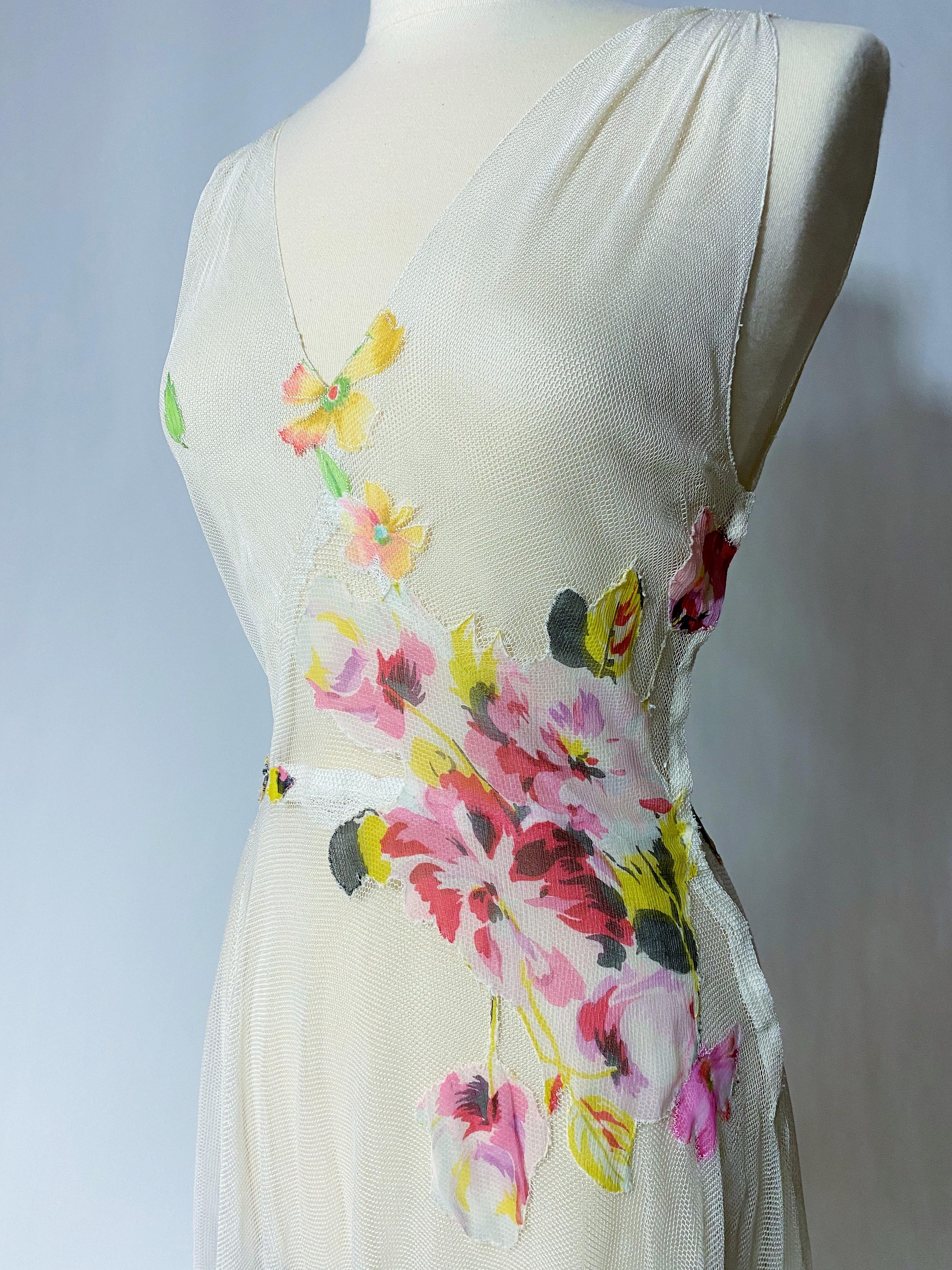 Ca. 1935-1940

Frankreich

Langes Sommerkleid aus weißem Baumwollnetztüll, überzogen mit floral bedrucktem Seidenchiffon, aus den späten 1930er Jahren, mit vermeintlicher Romantik. Ärmelloses Kleid mit tiefem V-Ausschnitt, seitlich mit Druckknöpfen