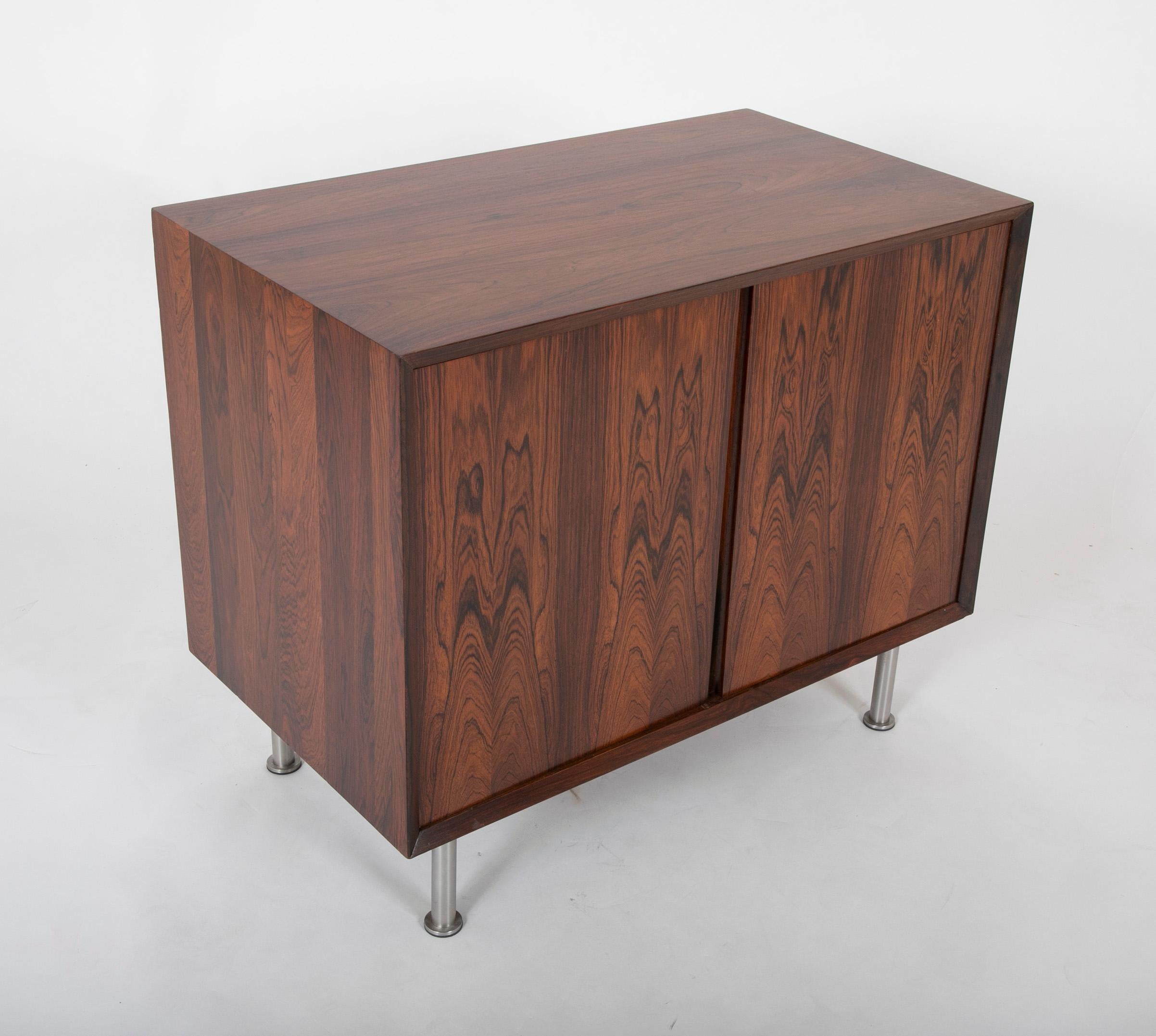 A possibly Danish; rosewood cabinet having chrome leg. Having a single ebonized internal shelf.