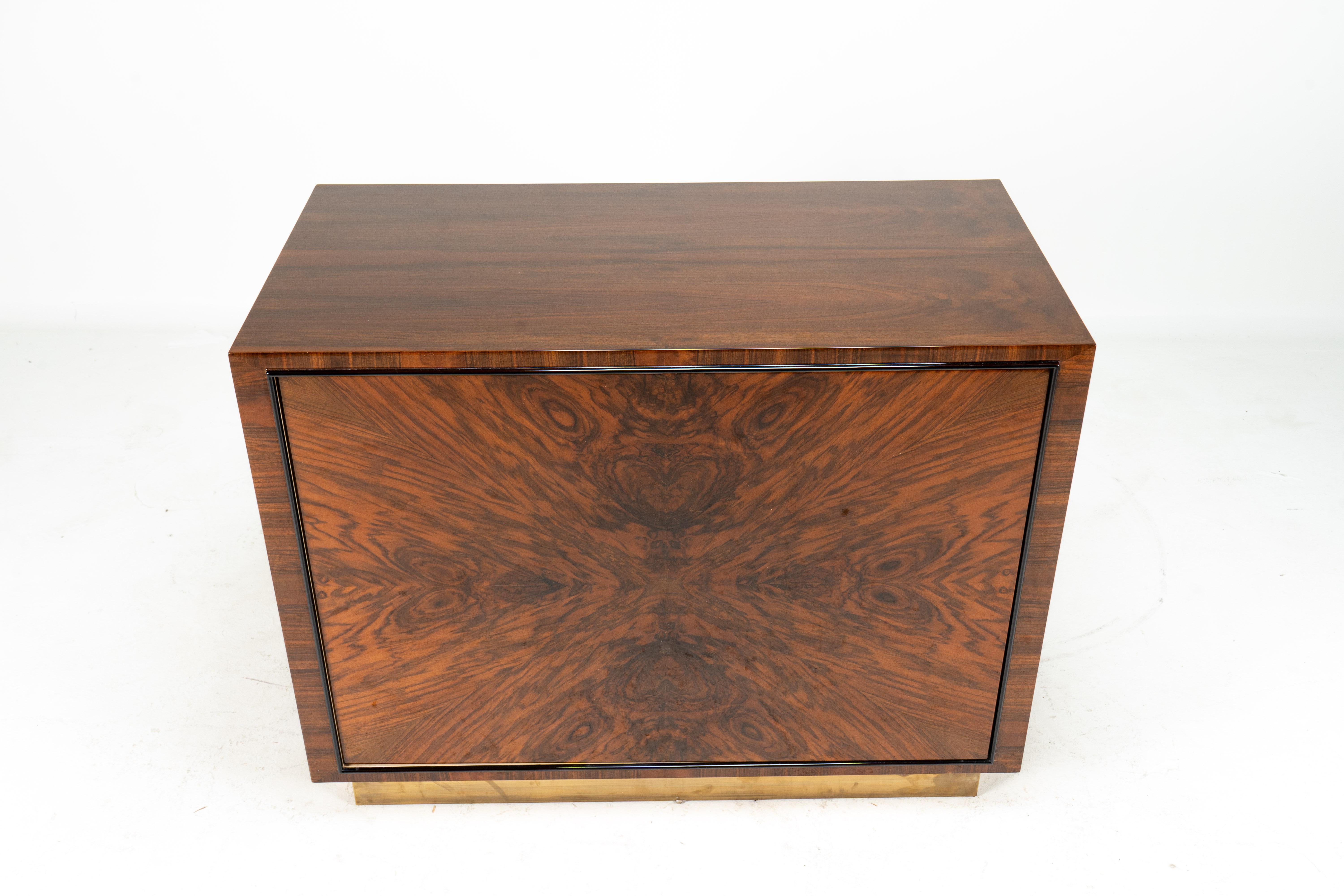 This extraordinary bar cabinet has a glossy case made from walnut veneers and a rotating door covered in book-matched walnut burl. The door is opened by pressing on one side. The action is smooth and polished as the door swings open to reveal three
