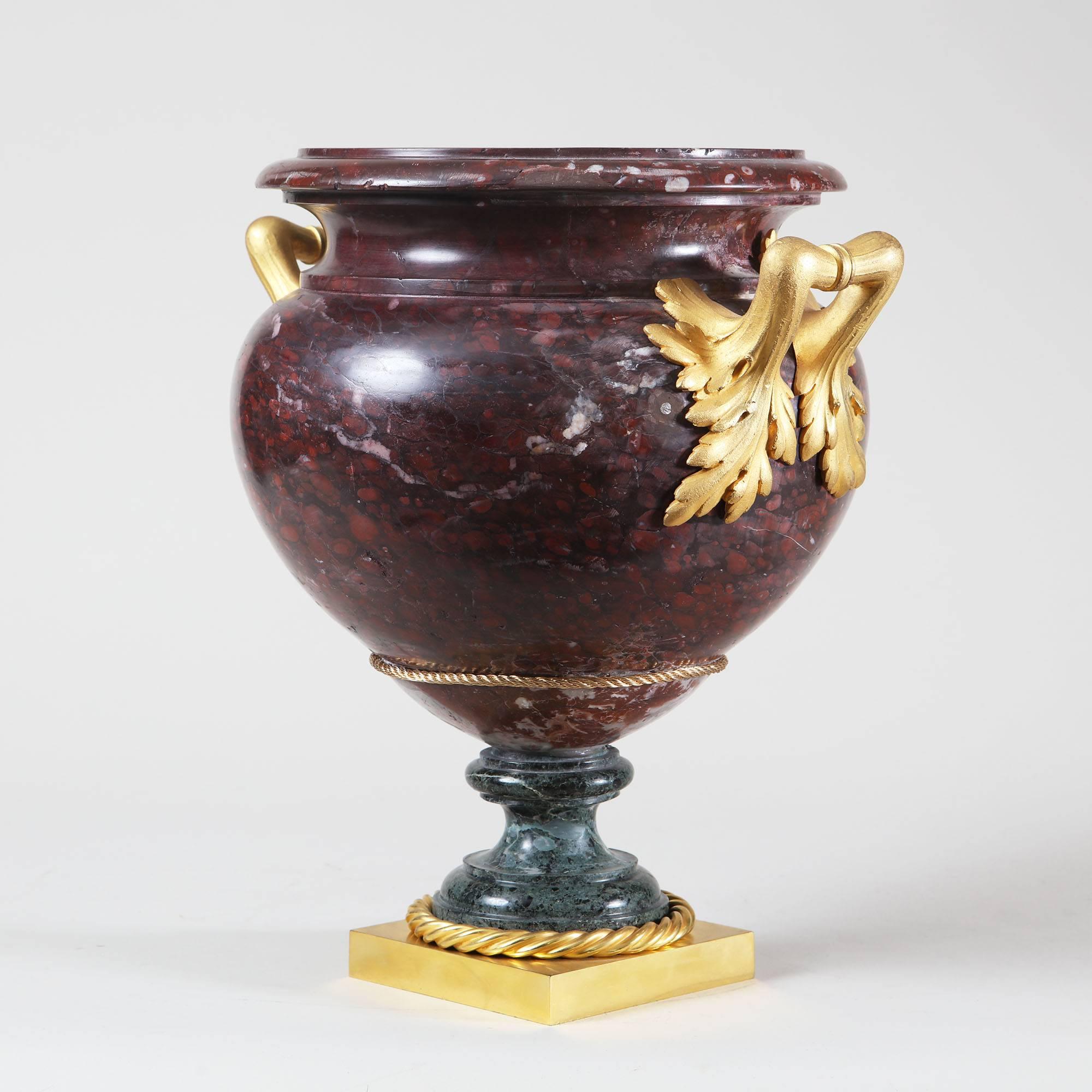 A Rouge Griotte Marble and Green Marble Urn with Ormolu Mounts
The top antique, the base later. 

Measures: 38 cm high, 36 cm wide, 30 cm deep.