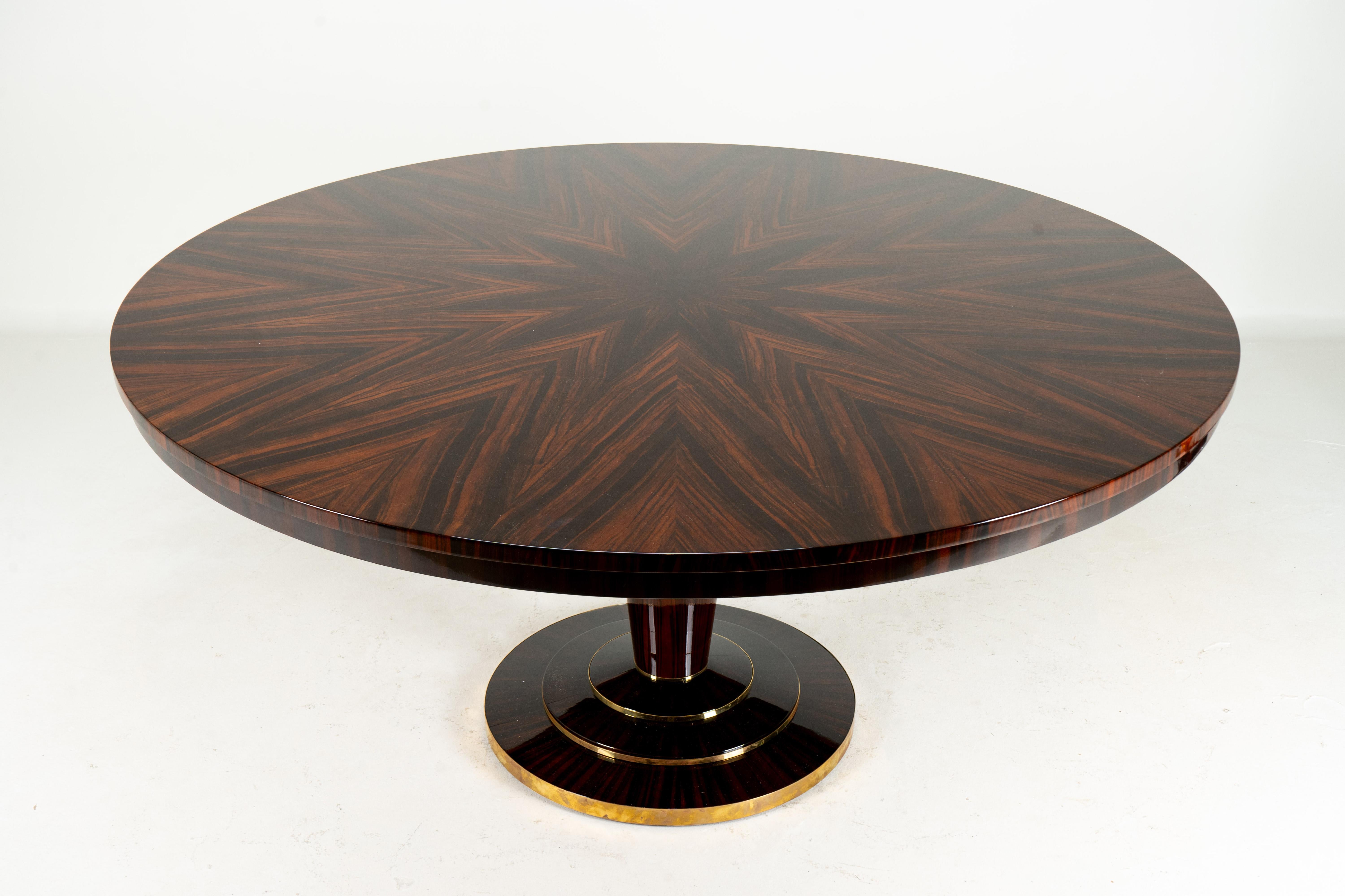 Cette superbe table de salle à manger circulaire est resplendissante en placage de macassar disposé en étoile. Le dessin est constitué de 8 pointes de tarte formées à partir de 32 pièces de placage. Le macassar, une sous-espèce d'ébène, a été