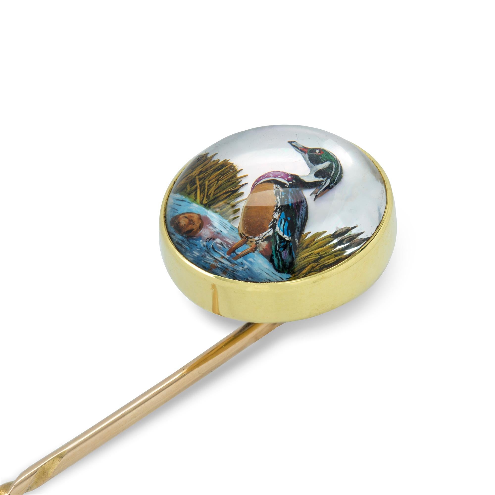 A round Essex crystal stick pin, the cabochon-cut crystal depicting a bird, set on an 18ct gold rub-over mount, to gold pin fitting, circa 1900, the jewelled part measuring 1.4cm in diameter, the pin measuring 6.8cm, gross weight 5 grams.

This