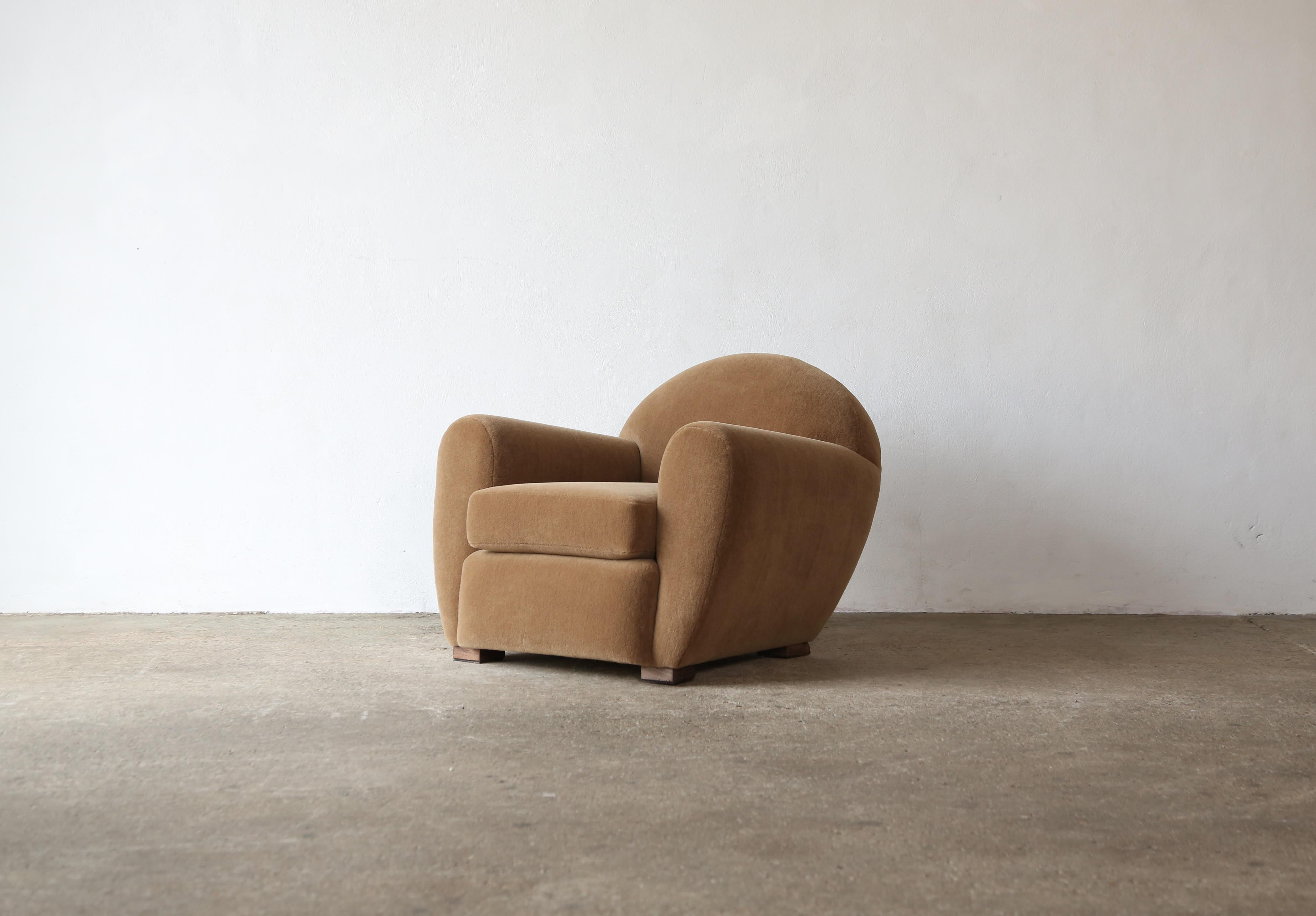 Magnífico sillón club moderno, redondo e inclinado, tapizado en tela de alpaca pura.  Armazones de haya de alta calidad hechos a mano y tapizados en un suave tejido marrón dorado de lana de alpaca 100% de primera calidad.   Disponible con otomana -