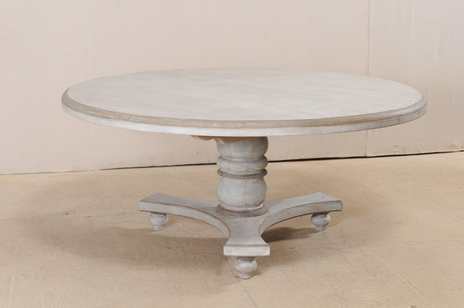 A lovely round-shaped pedestal table which has been newly fashioned making use of old recycled jackwood. The table features a round top, approximately 5.5' in diameter, atop a thickly turned center pedestal with tripod base extending out, supported
