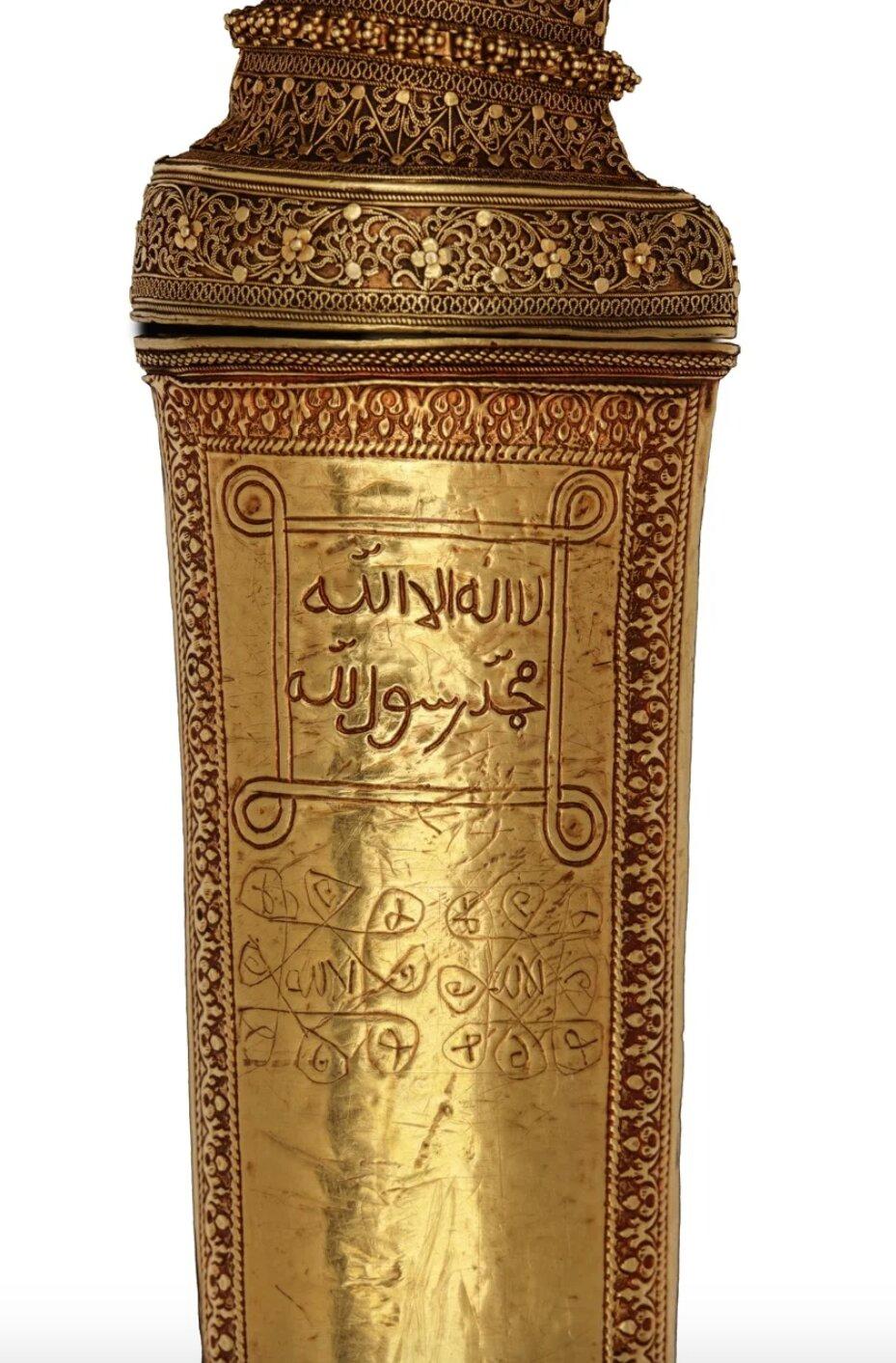 A Royal Indonesian Buginese gold and buffalo horn badek dagger

Indonesia, Sulawesi, 1st half 18th century

L. 54 cm
?
The solid gold scabbard is inscribed with a magic square, as well as inscribed in Arabic: La ilaha illallah Mohammed ur