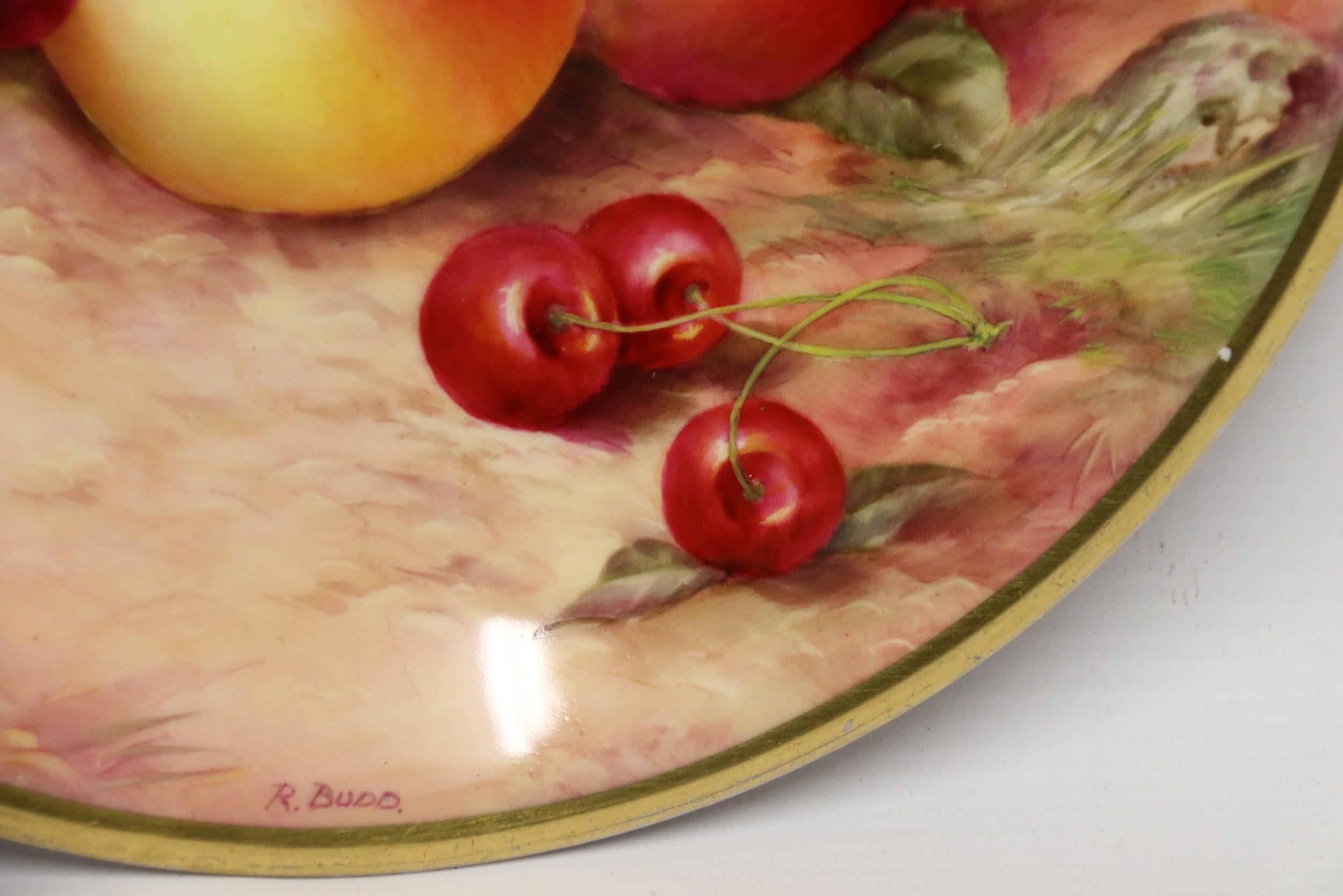This rich and exotic plate has a finely hand painted still life fruit group consisting of cherries, apples, red, green grapes and a peach on a leafy bank.

It was produced and date marked from the Royal Worcester Factory in 1931 with the double