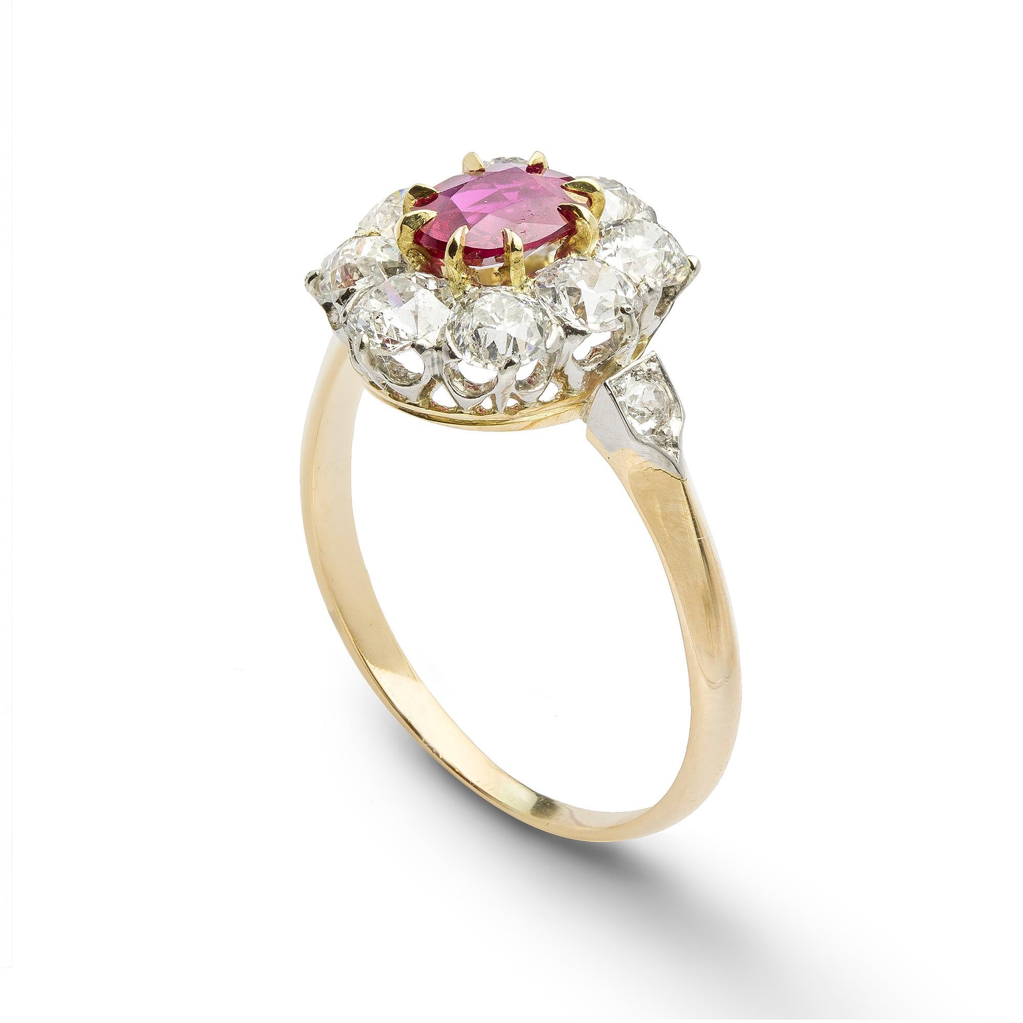 A ruby and diamond cluster ring, the oval faceted ruby estimated to weigh 0.65 carats, surrounded by eight old brilliant-cut diamonds estimated to weigh 1.35 carats in total, all claw set in a white to yellow gold mount with diamond set